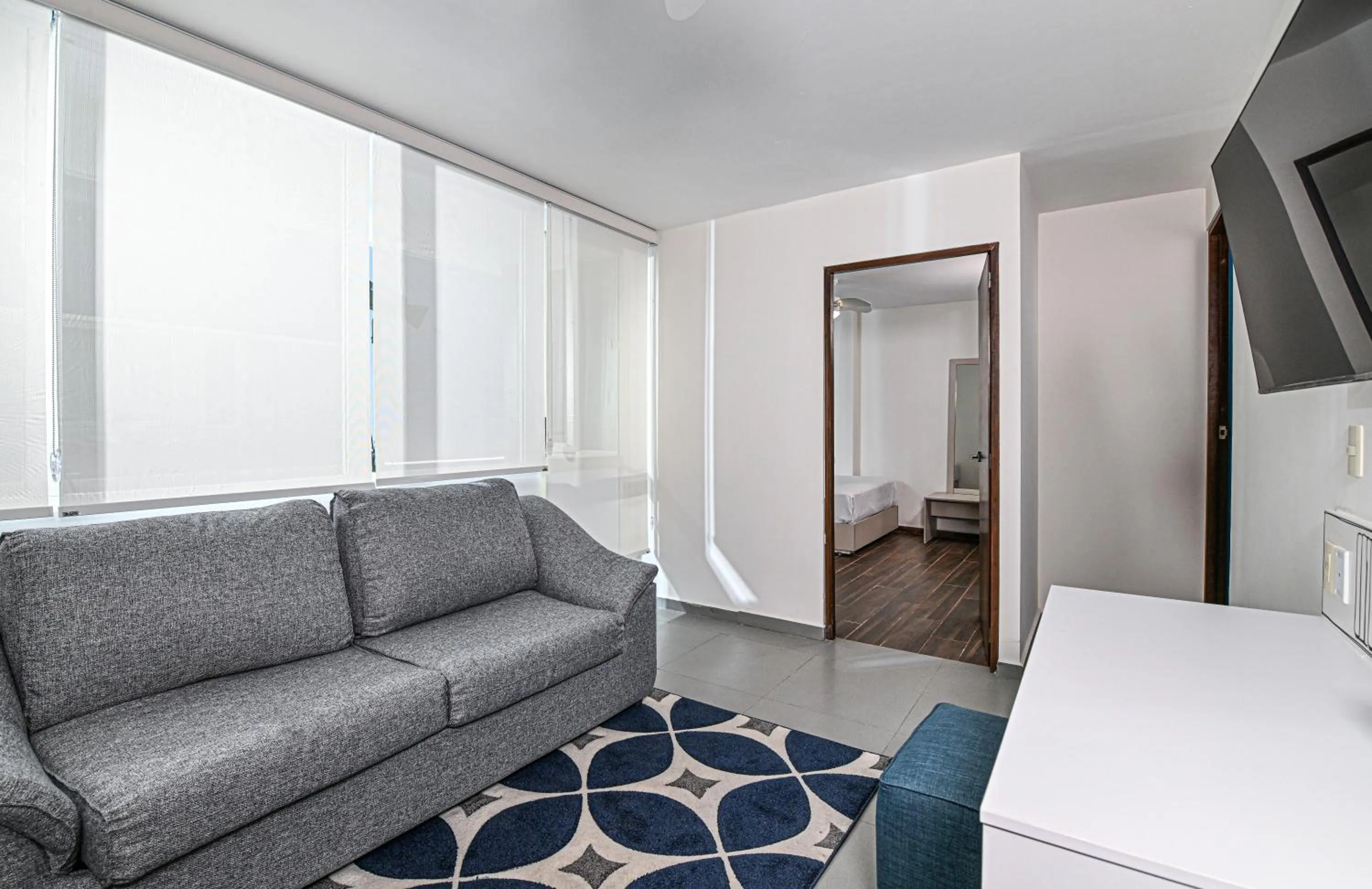 Living room, Bed in Vista Express Guadalajara Expo SureStay Collection by BW