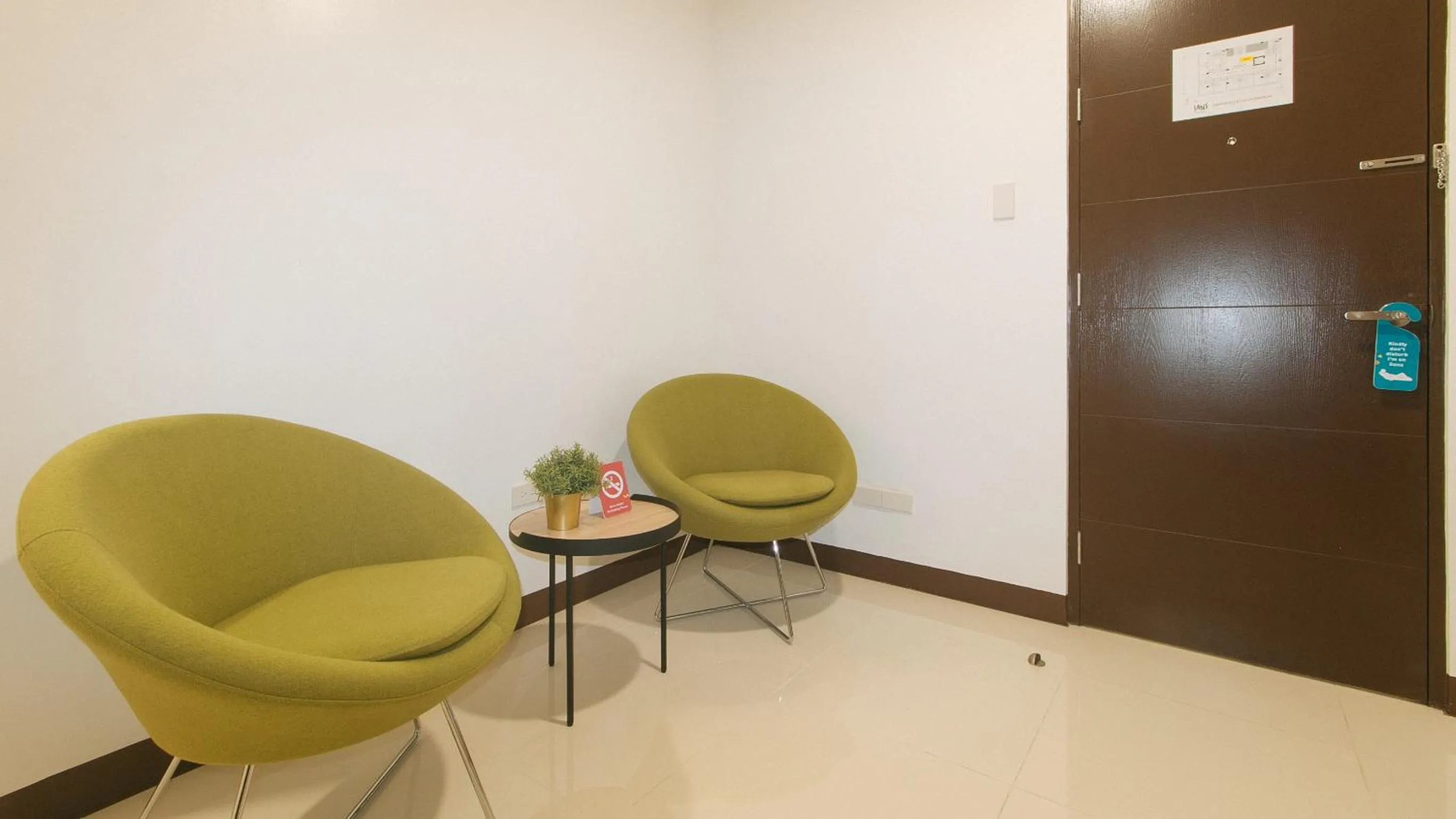 Seating area in Sans Hotel at One JD Place Makati by RedDoorz