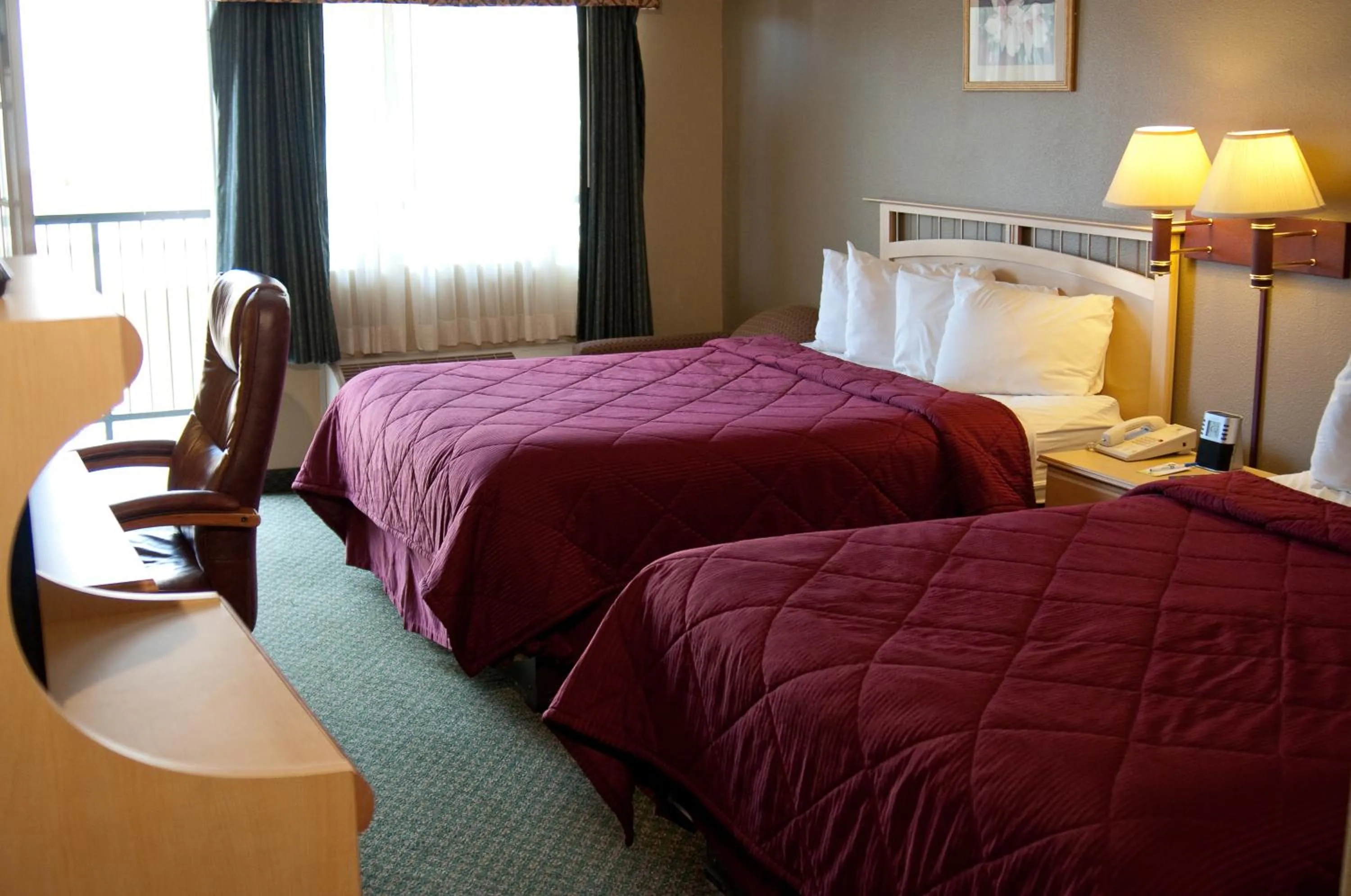 Bed in Lamplighter Inn & Suites