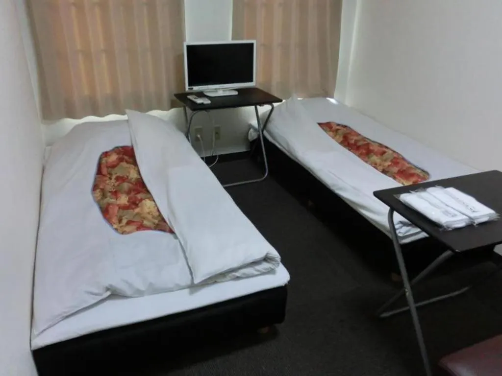 Bed in New Shochikubai Hotel