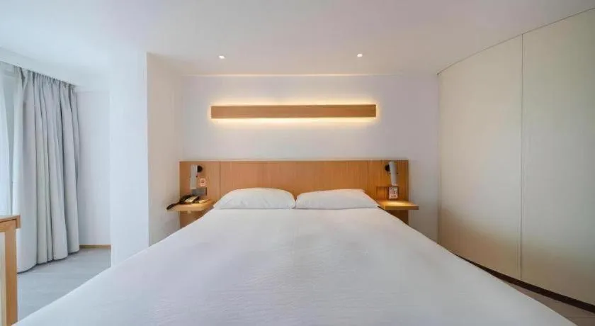 Bed in Meijin All Suites Hotel Suzhou