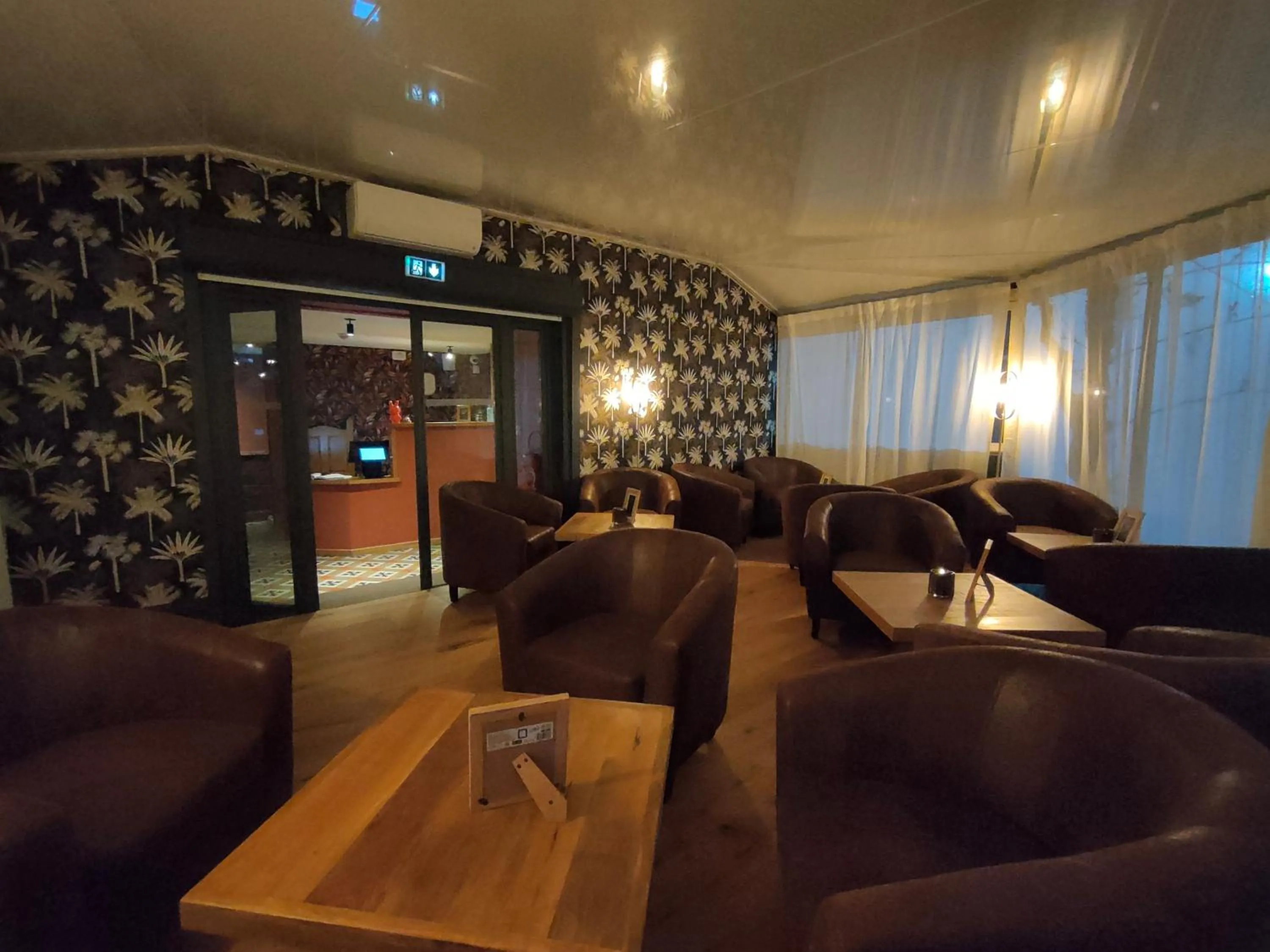 Communal lounge/ TV room in Hôtel Restaurant L'Art des Mets by Côté Jardin