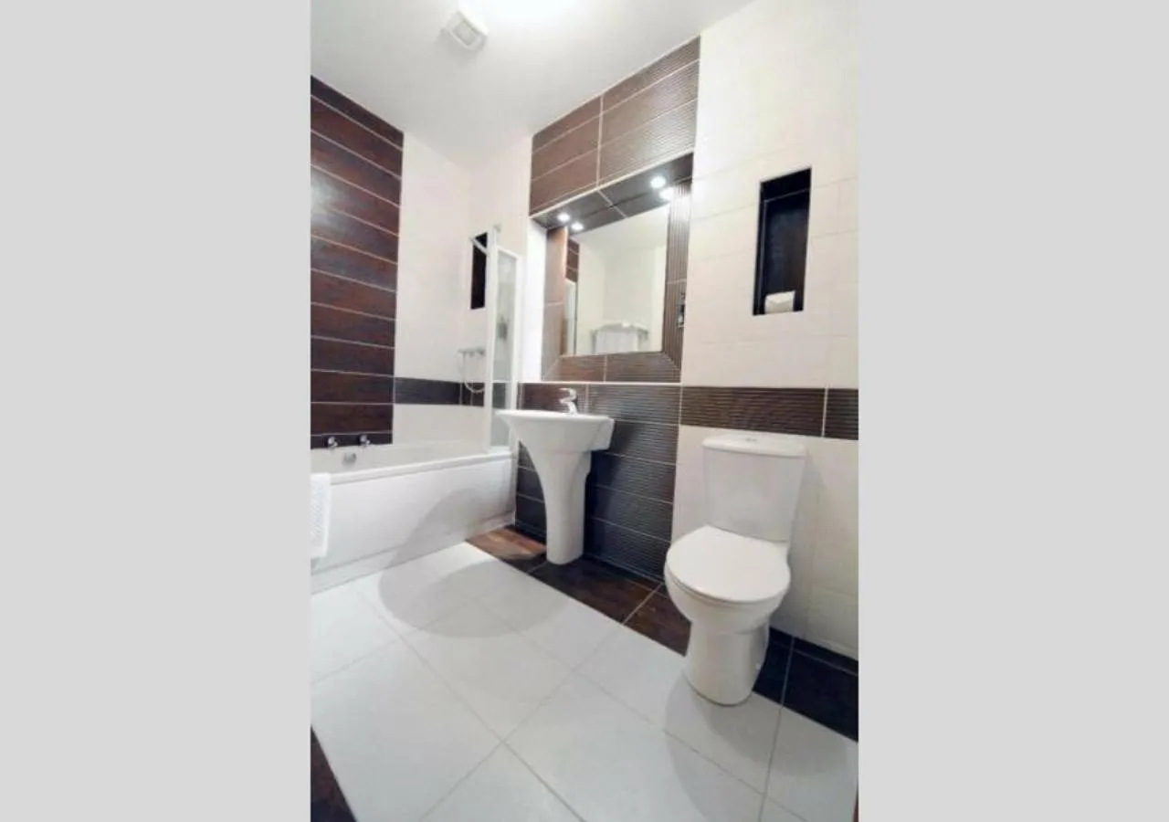 Bathroom, Bed in Carrick Plaza Suites and Apartments