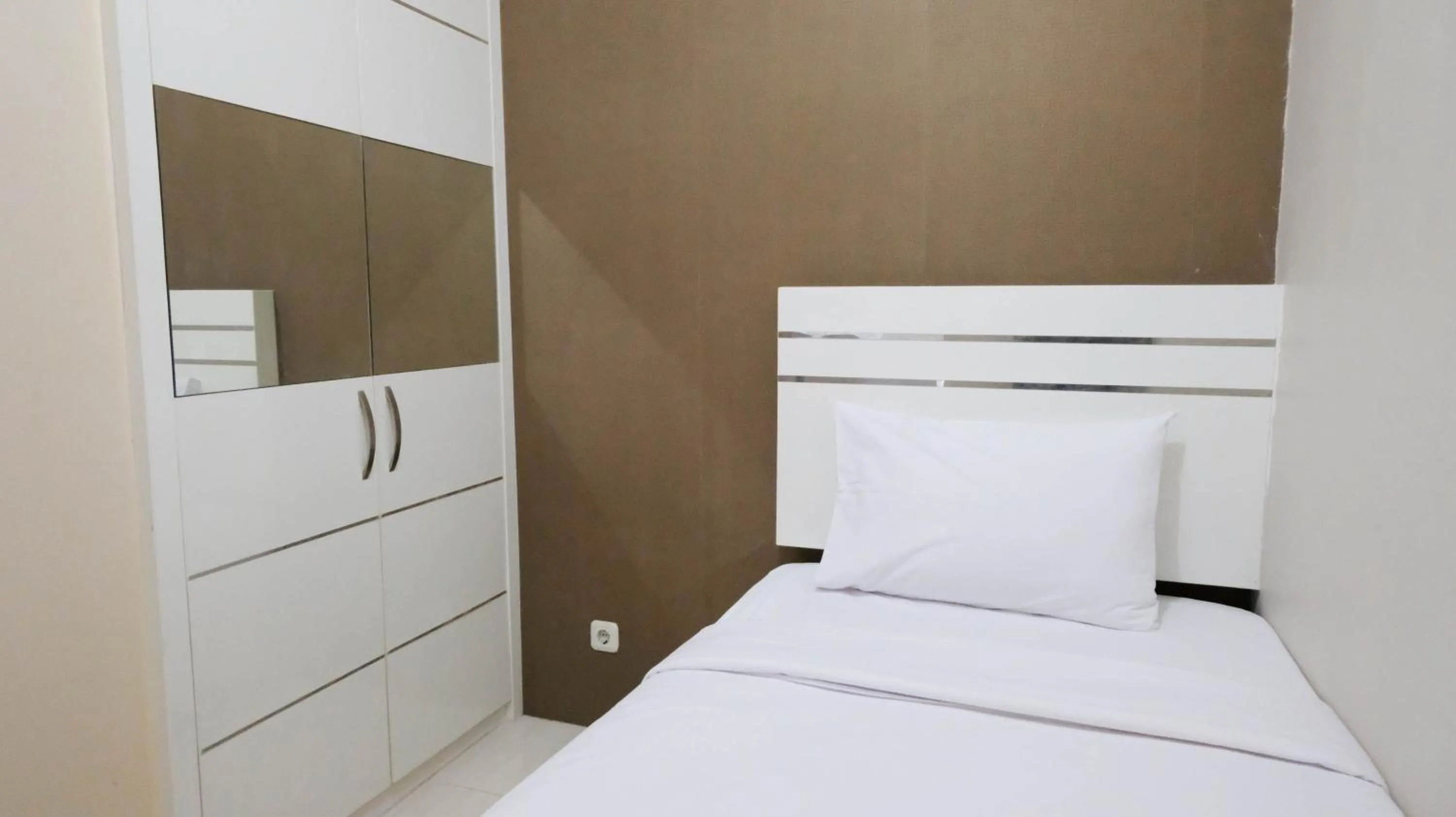 Bed in Homey 2BR at Puncak Bukit Golf Surabaya Apartment By Travelio
