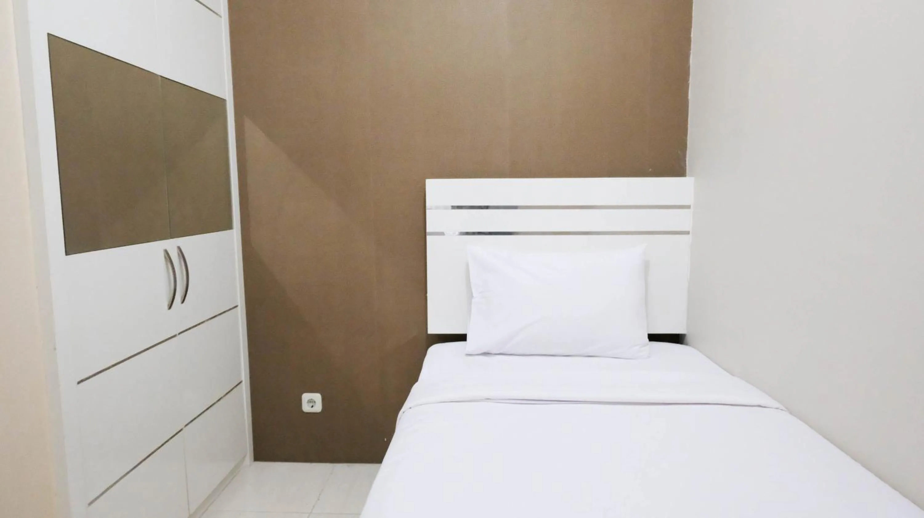 Bed in Homey 2BR at Puncak Bukit Golf Surabaya Apartment By Travelio