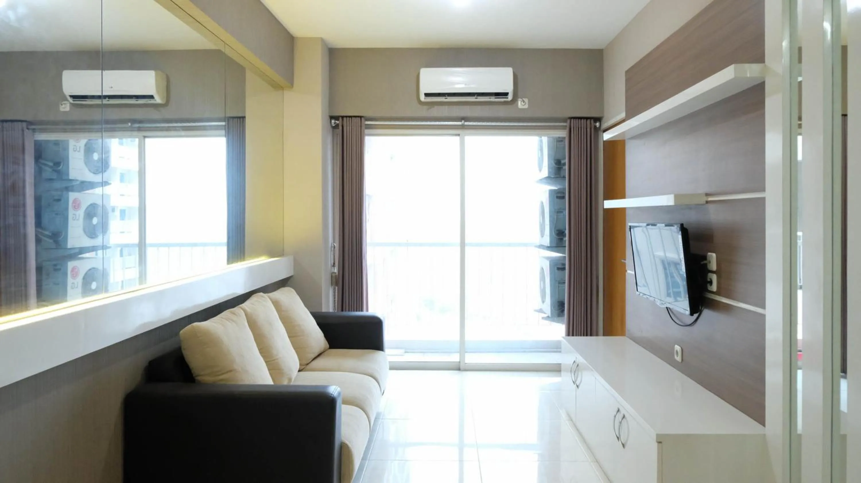 Living room in Homey 2BR at Puncak Bukit Golf Surabaya Apartment By Travelio