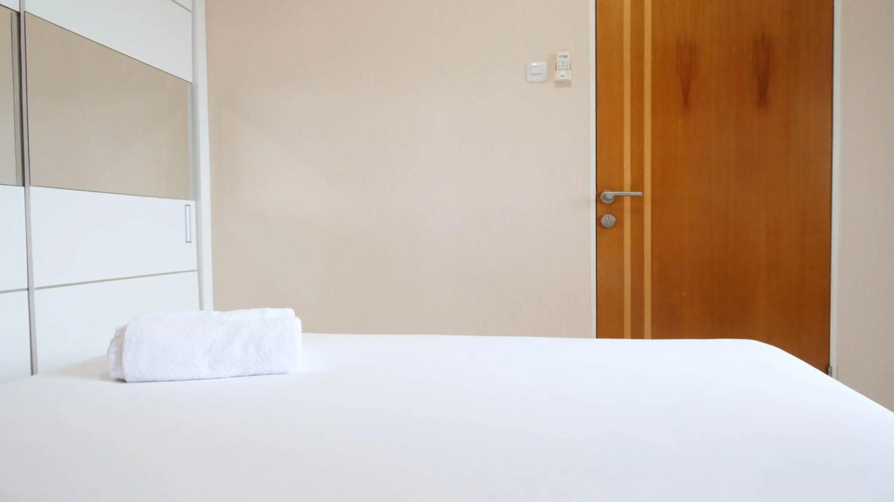 Bed in Homey 2BR at Puncak Bukit Golf Surabaya Apartment By Travelio