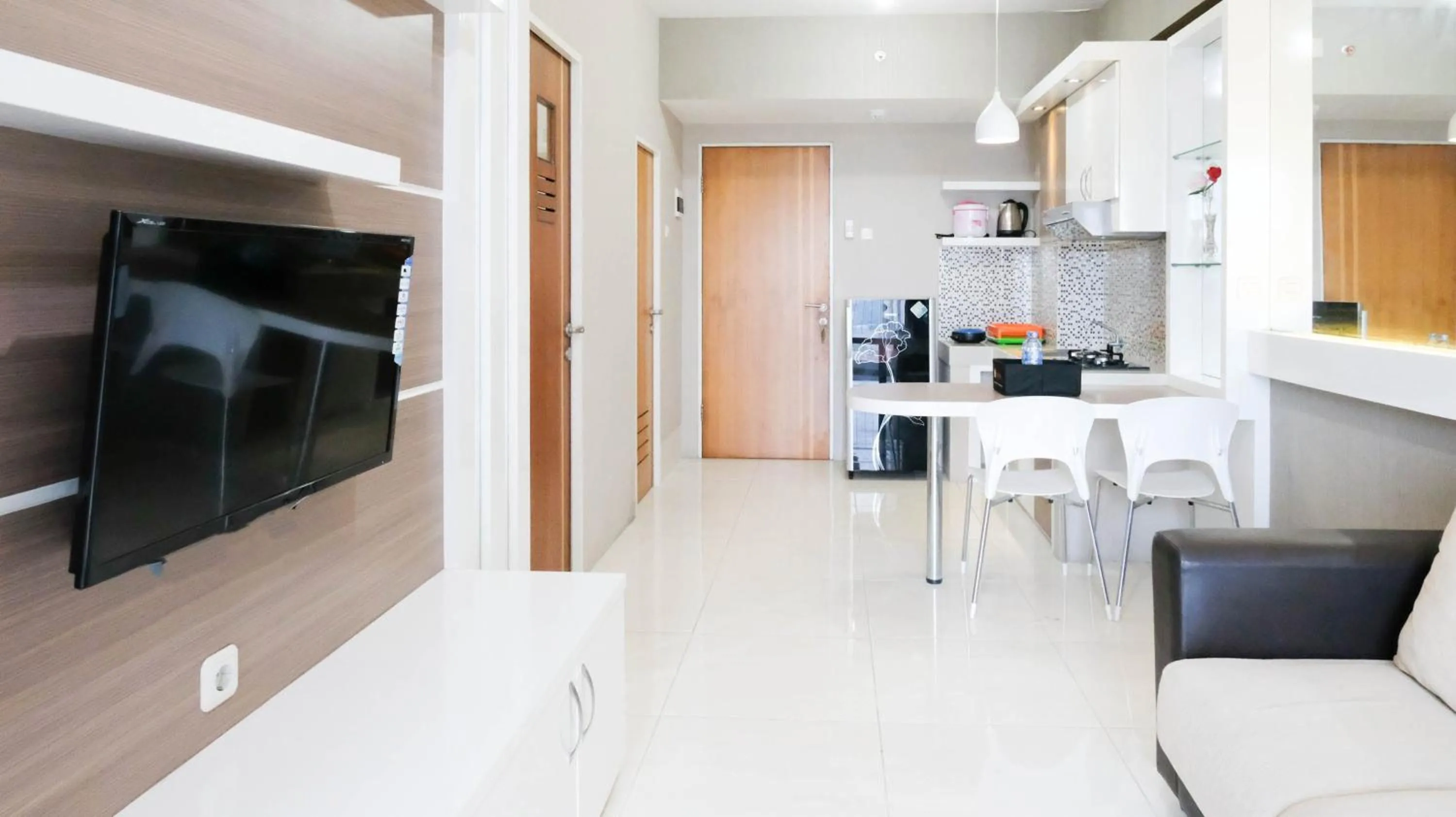 Living room in Homey 2BR at Puncak Bukit Golf Surabaya Apartment By Travelio