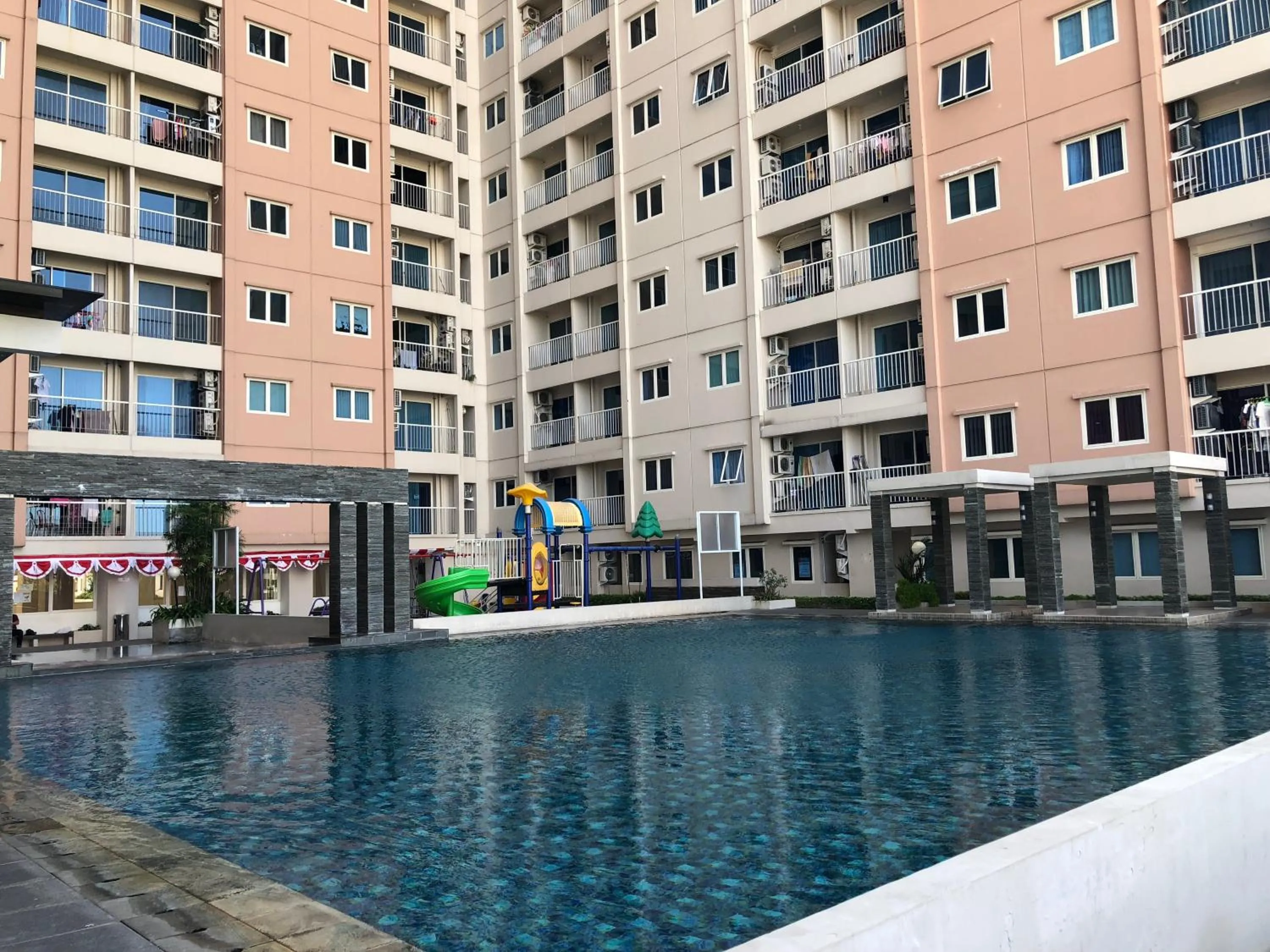 Swimming pool in Homey 2BR at Puncak Bukit Golf Surabaya Apartment By Travelio