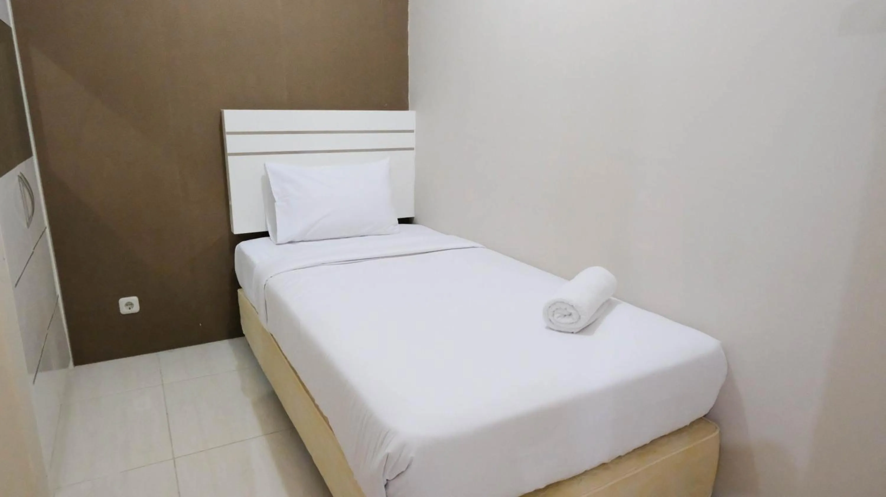 Bed in Homey 2BR at Puncak Bukit Golf Surabaya Apartment By Travelio