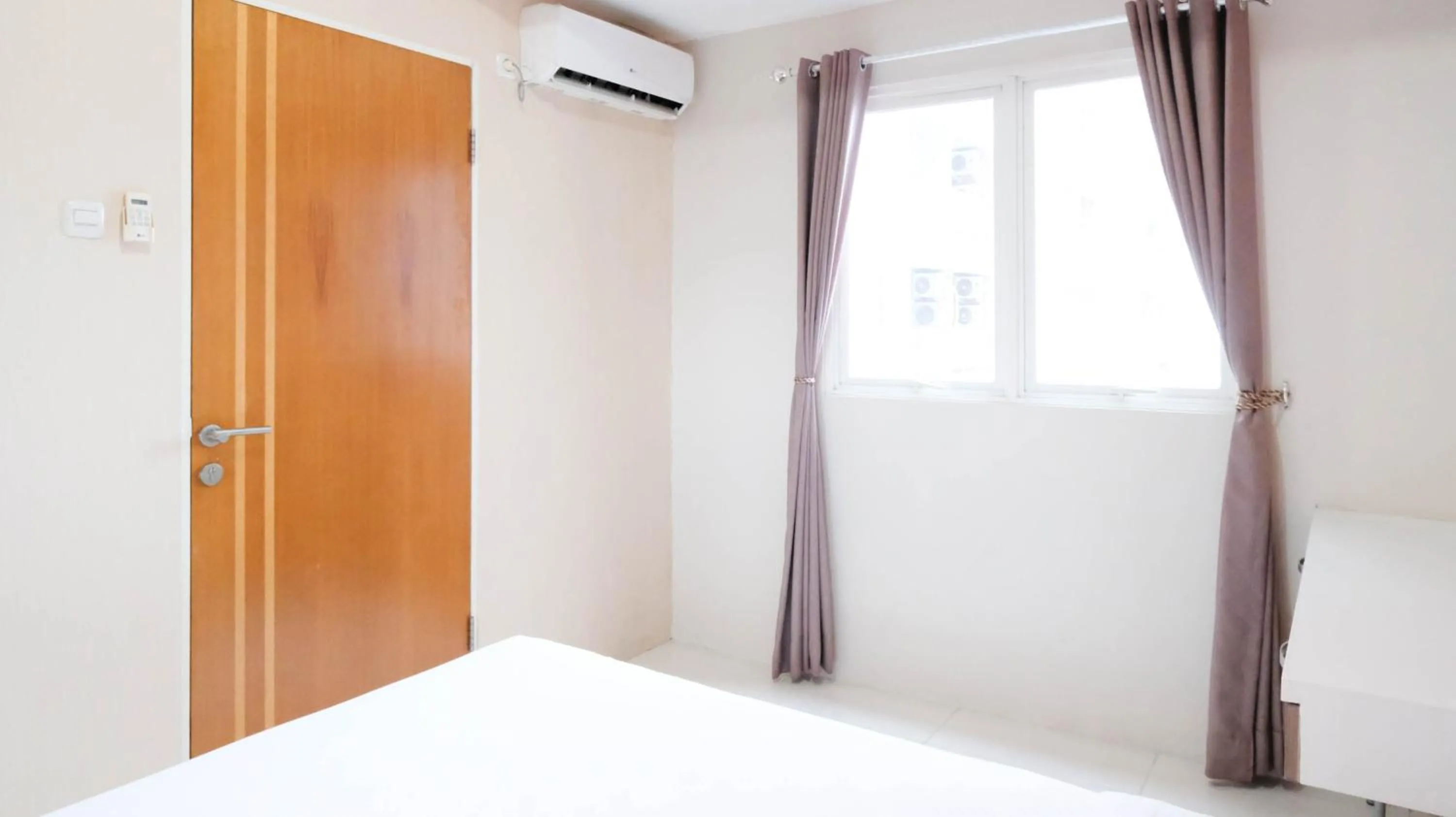 Bed in Homey 2BR at Puncak Bukit Golf Surabaya Apartment By Travelio
