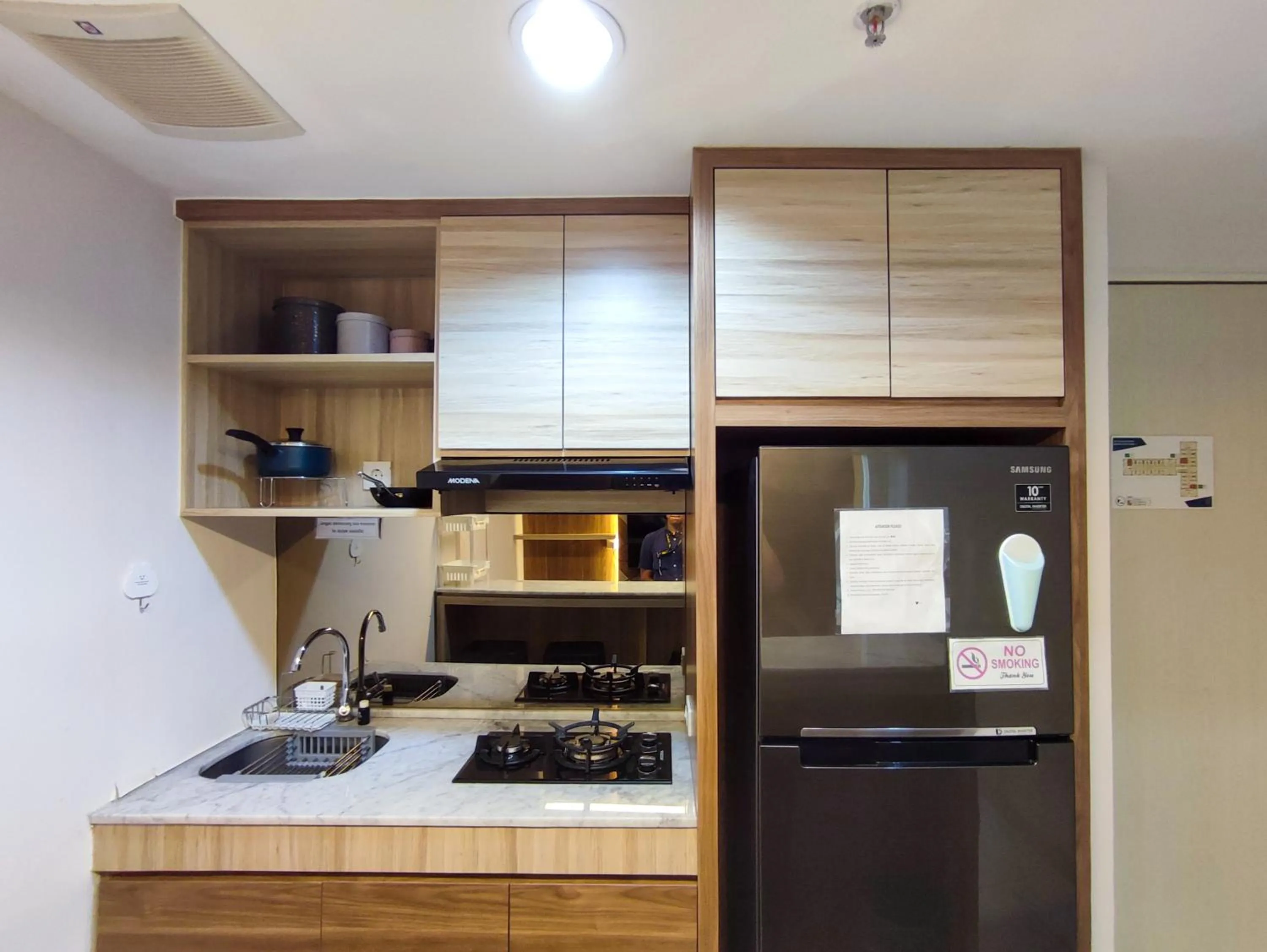 Kitchen or kitchenette in Fancy and Nice 1BR with Extra Room at Amartha View Apartment By Travelio
