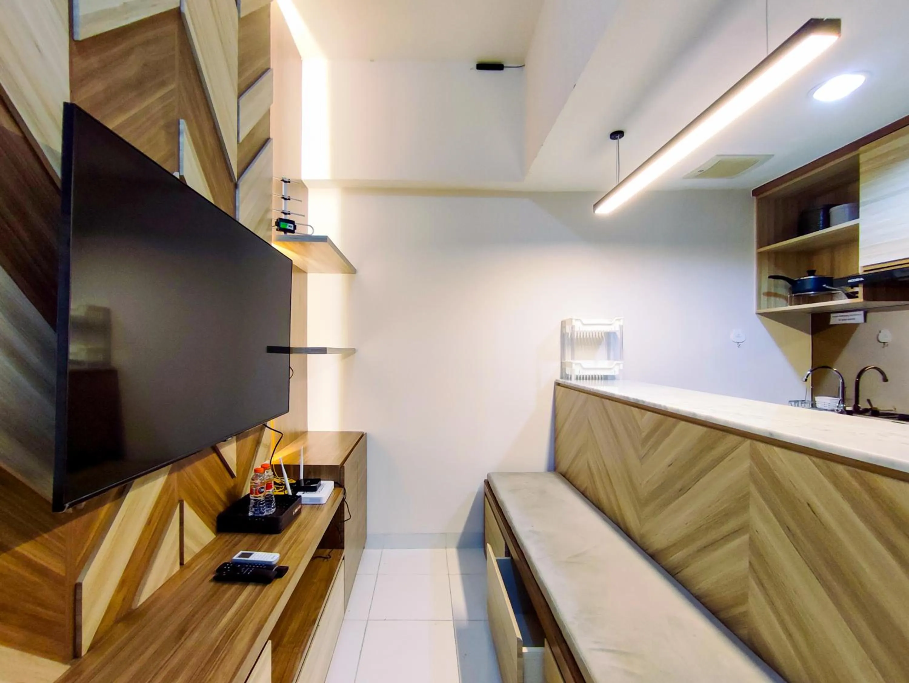 Living room in Fancy and Nice 1BR with Extra Room at Amartha View Apartment By Travelio