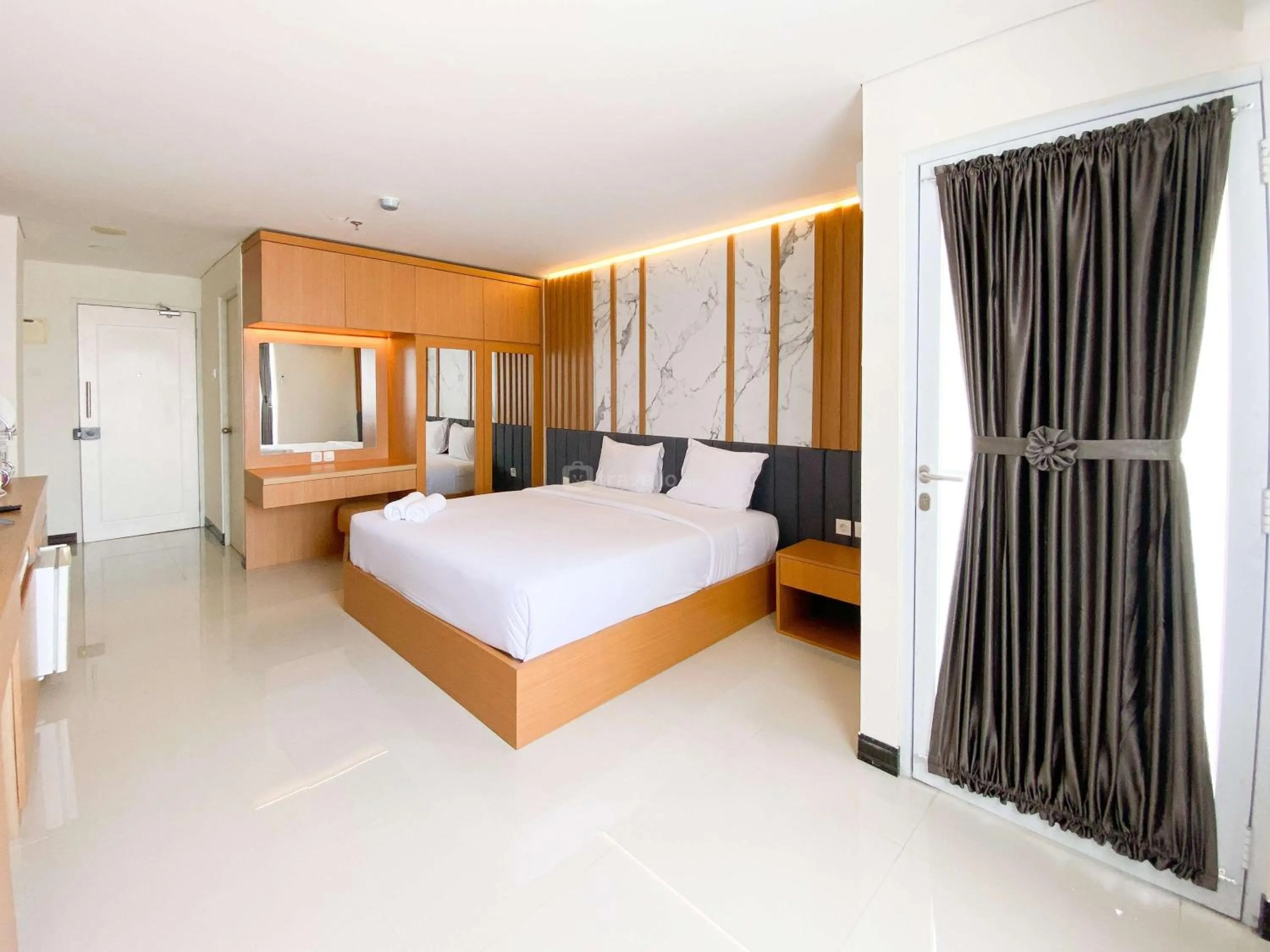 Bed in Homey and Strategic Studio (No Kitchen) at Sentraland Semarang Apartment By Travelio