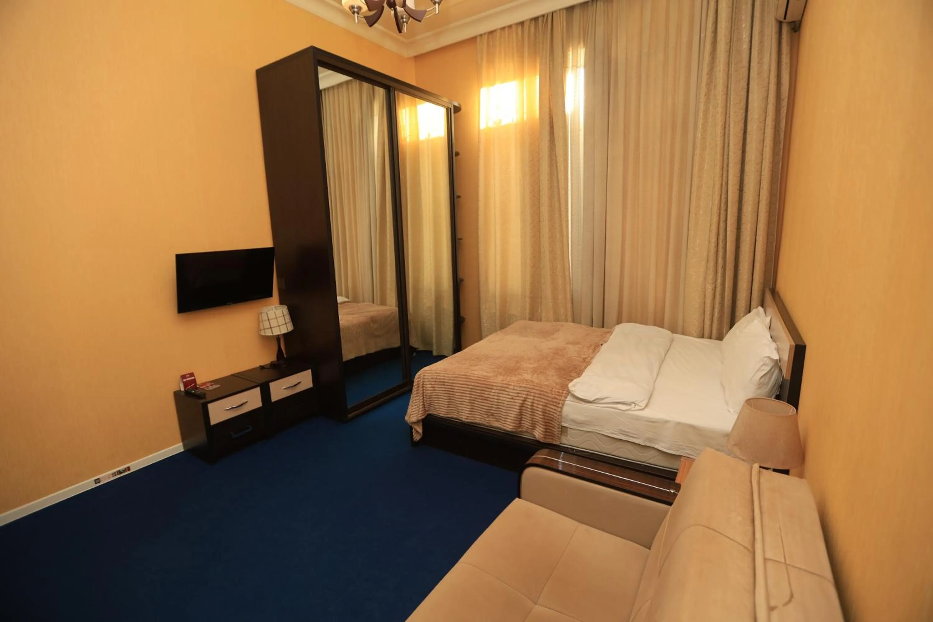 Communal lounge/ TV room, Bed in NH Nizami Hotel