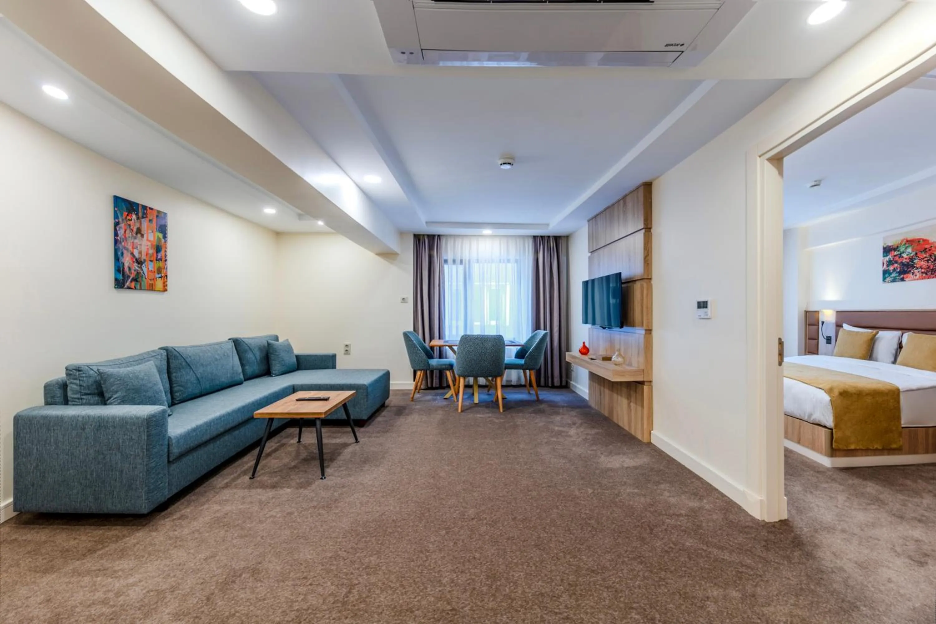 Communal lounge/ TV room, Bed in Roys Hotel & Suites