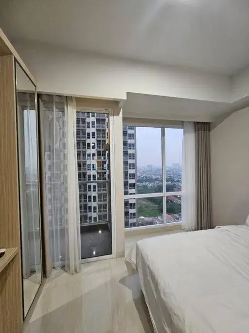 Bed in Green Sedayu Apartment Suite by Ellison Bed in Green Sedayu Apartment Suite by Ellison