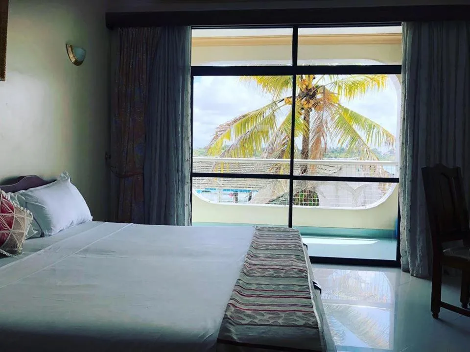 Bed in Tudor Water Sports Hotel