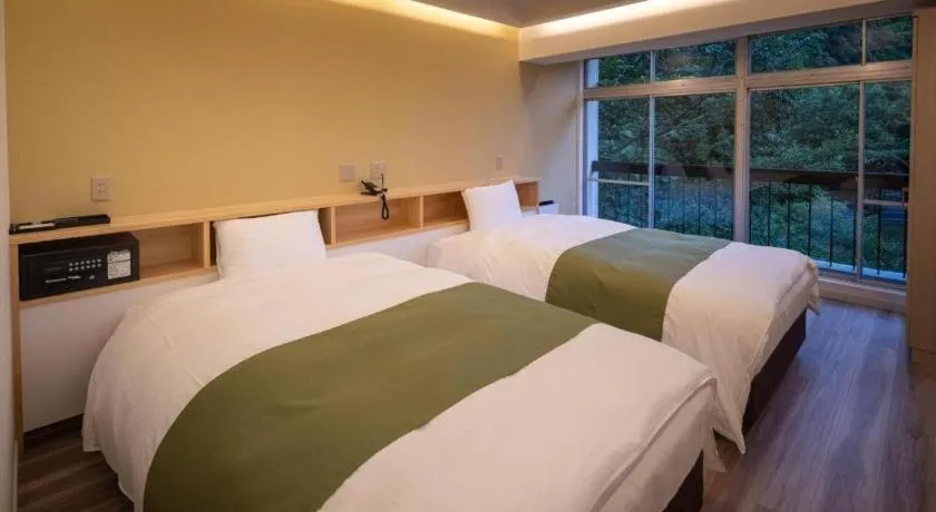Bed in Hotel Myoken Tanaka Kaikan