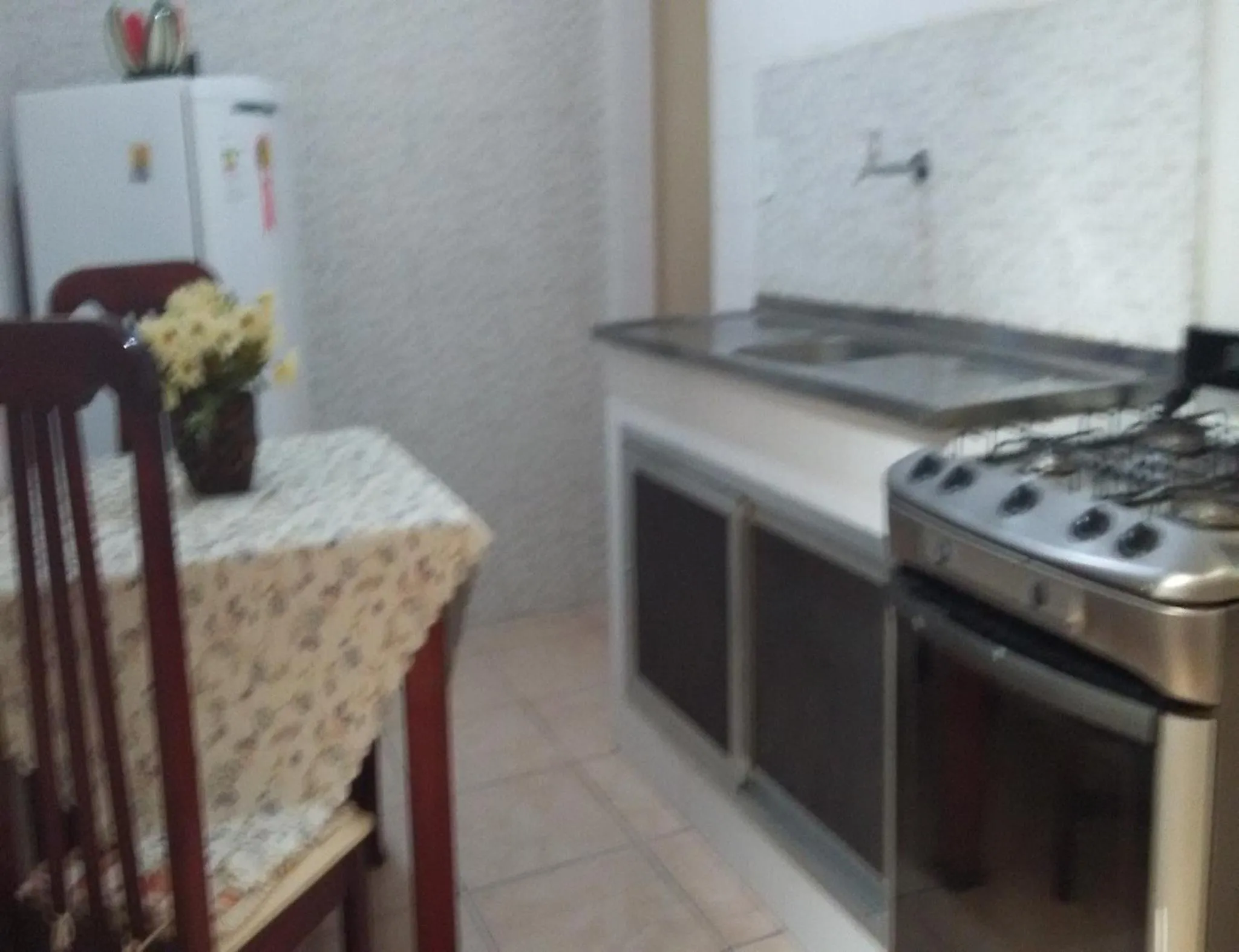 Communal kitchen in Quartos Em Casa In Caxias da Paraíso