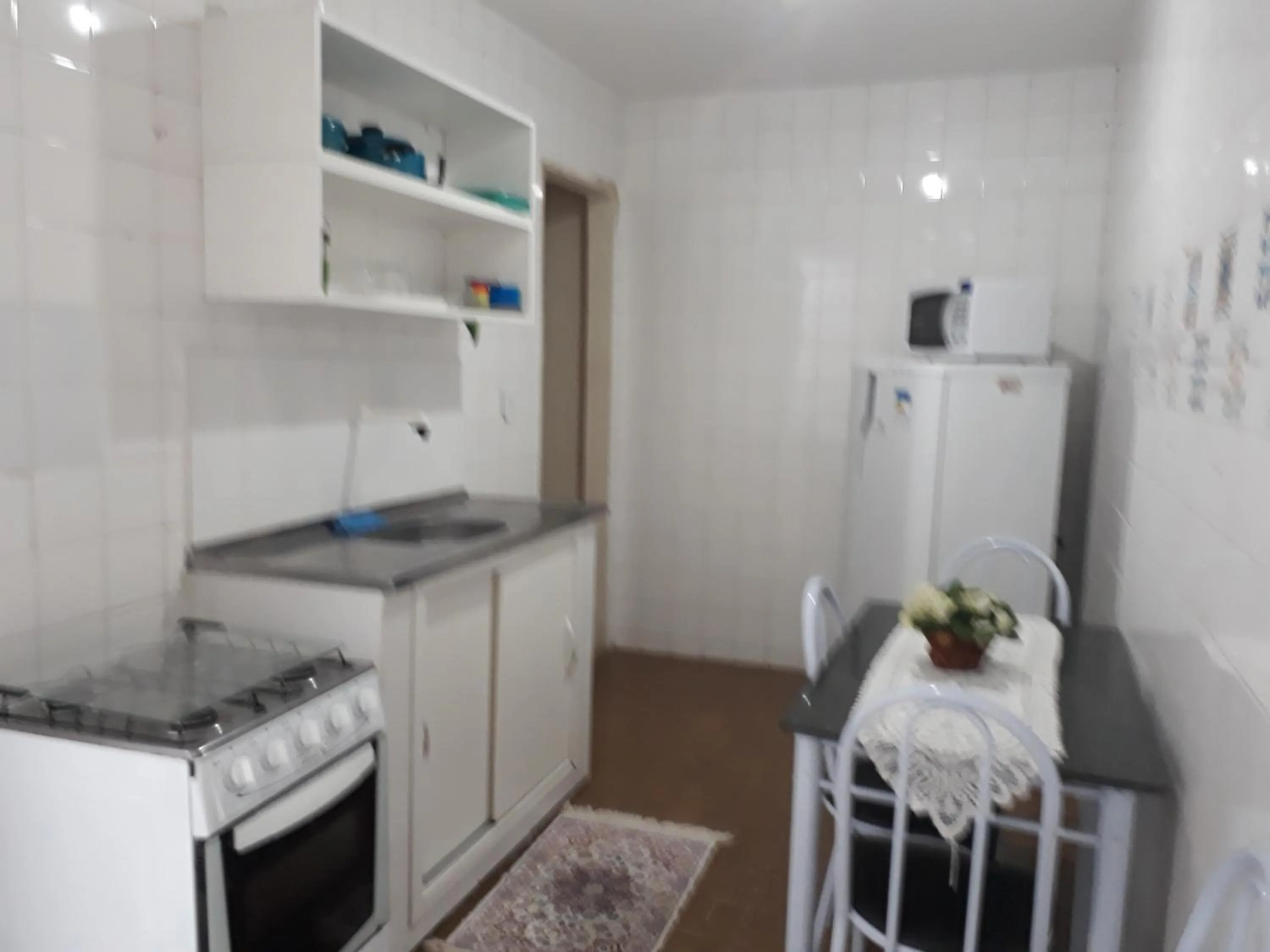 Communal kitchen in Quartos Em Casa In Caxias da Paraíso