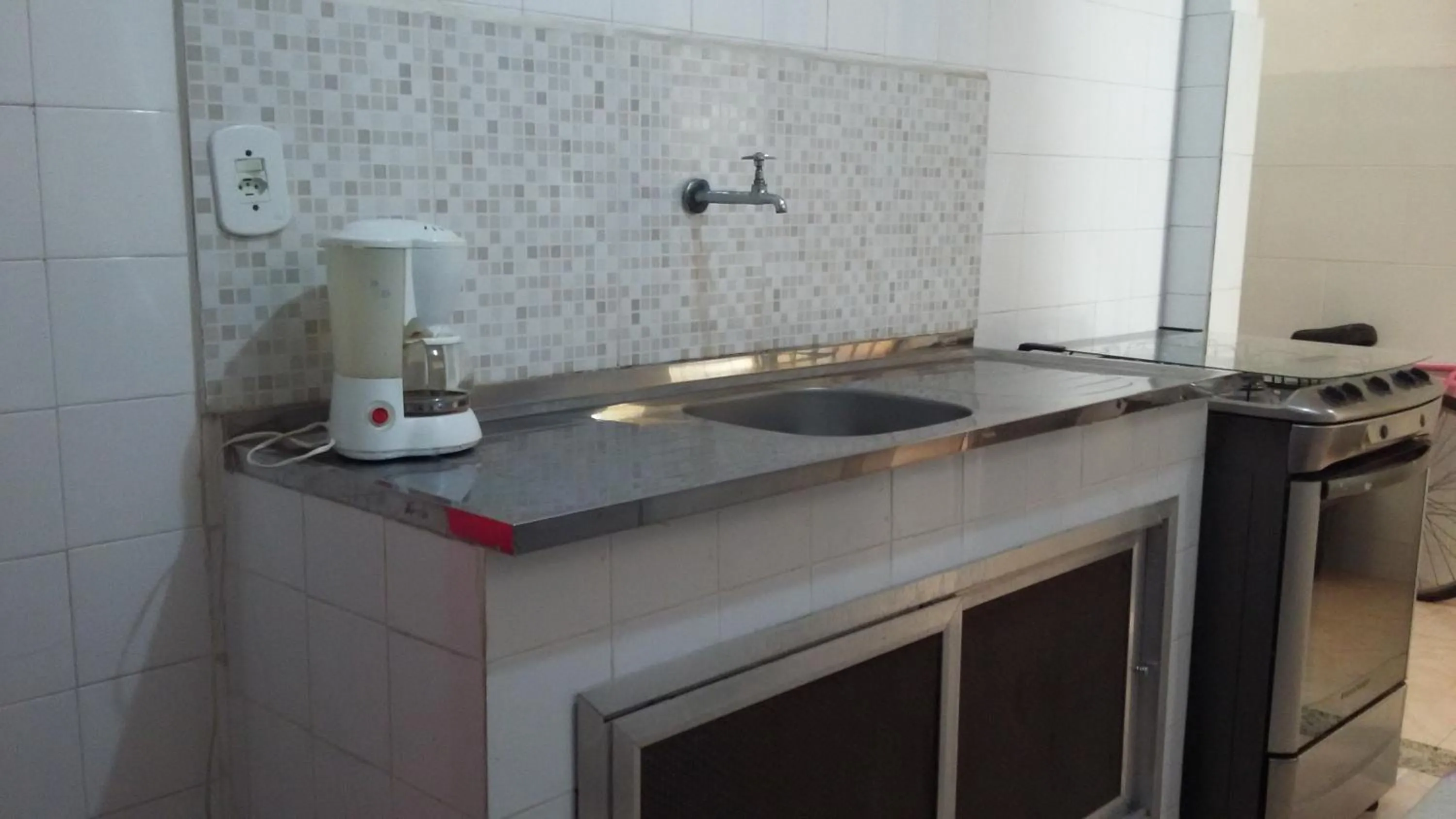 Communal kitchen in Quartos Em Casa In Caxias da Paraíso