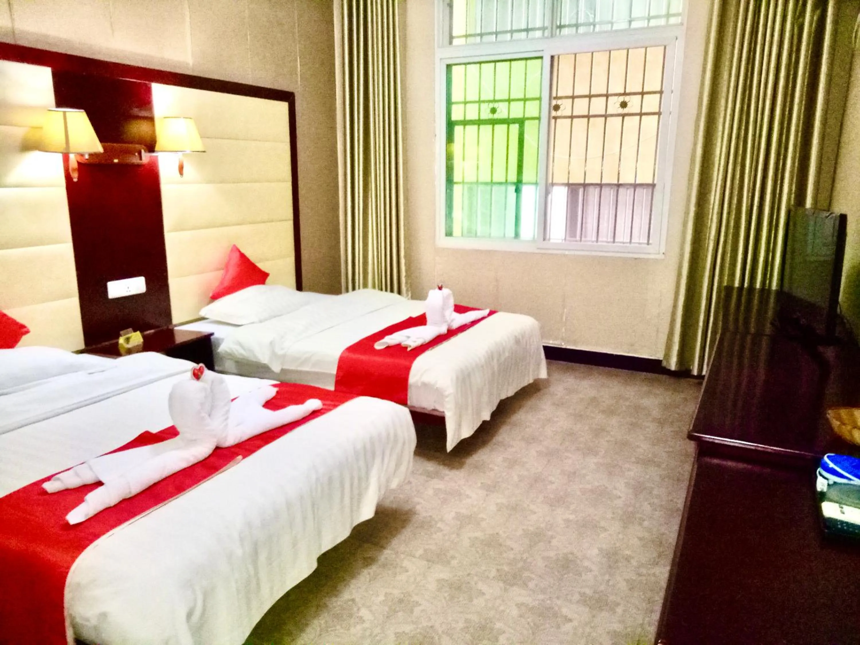 Bed in XiShuangBanNa International Aerial Garden South of Mekong River Business Hotel 傣江南商务酒店