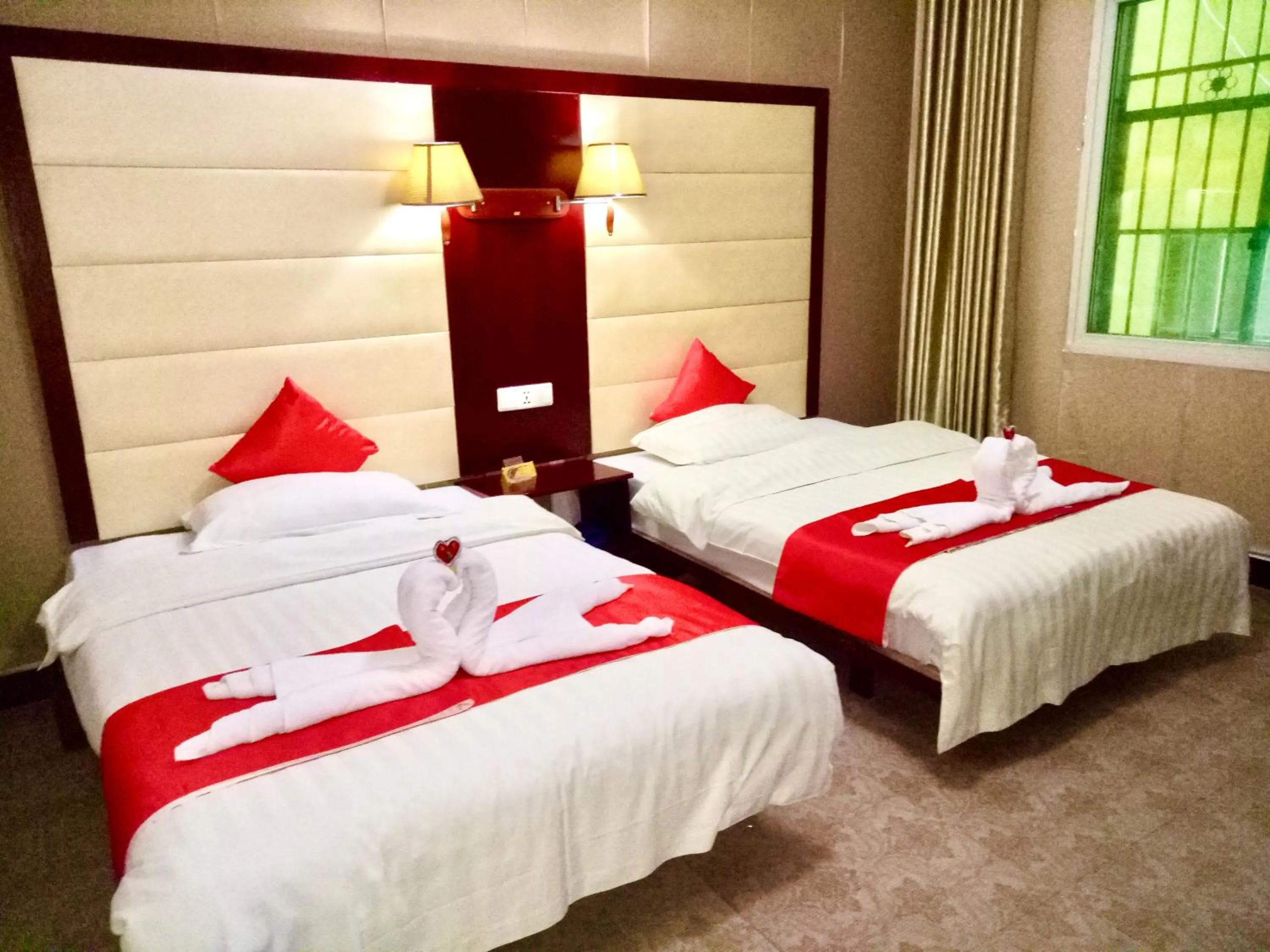 Bed in XiShuangBanNa International Aerial Garden South of Mekong River Business Hotel 傣江南商务酒店