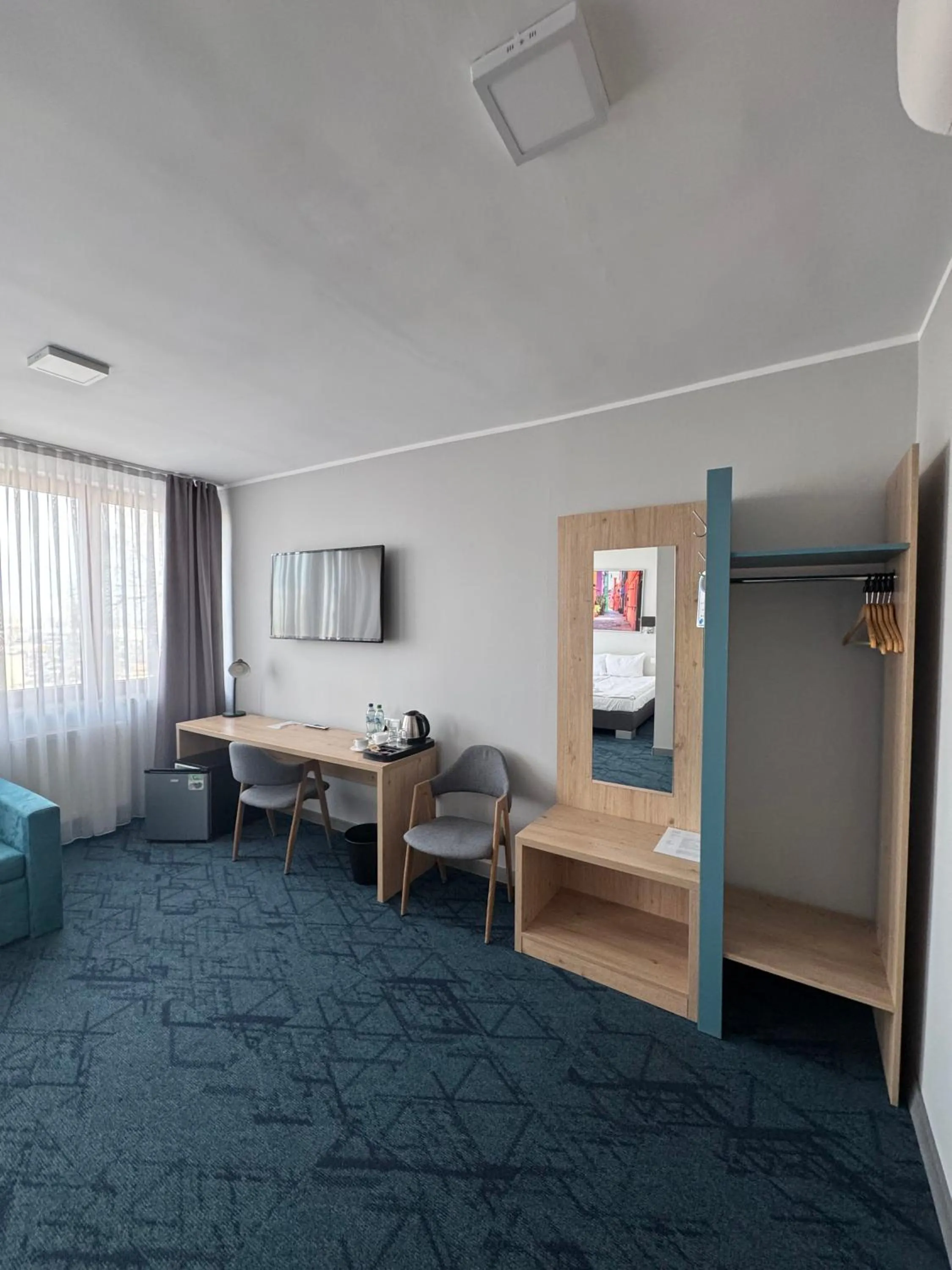 Communal lounge/ TV room, Bed in Carina Hotel