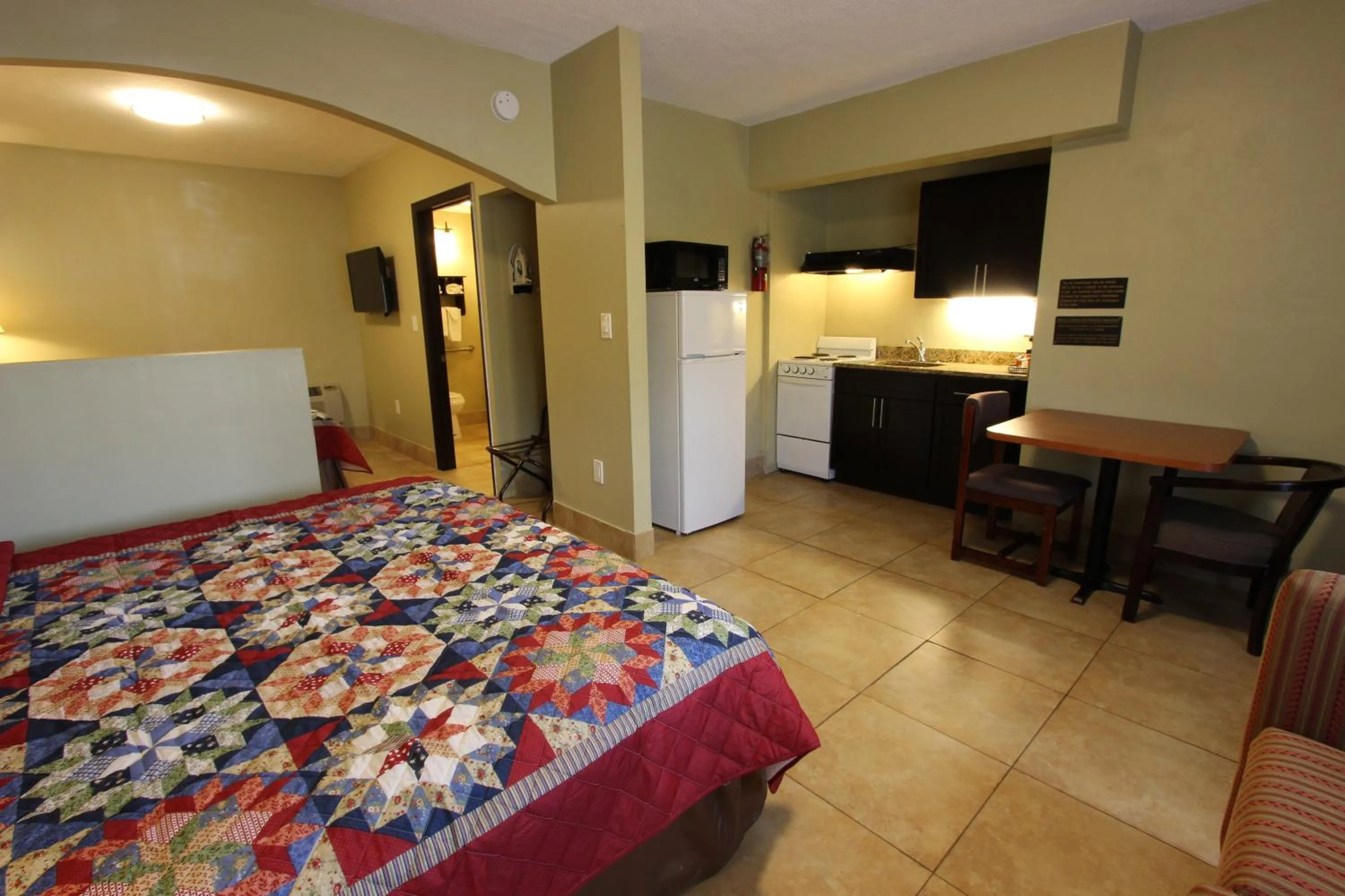 Kitchen or kitchenette, Bed in Oceans Beach Resort & Suites