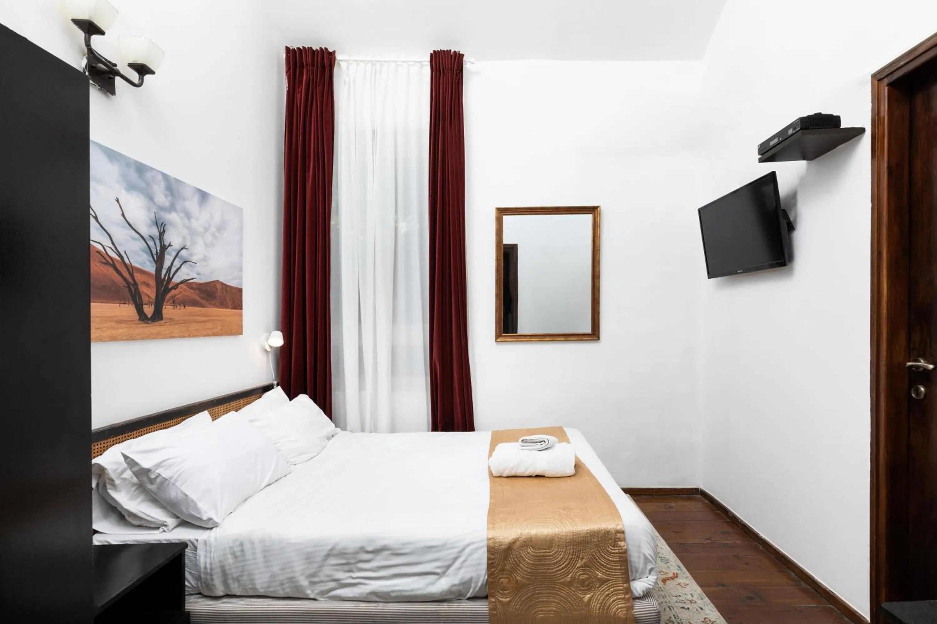 Bed, TV/Entertainment Center in The Colony Hotel