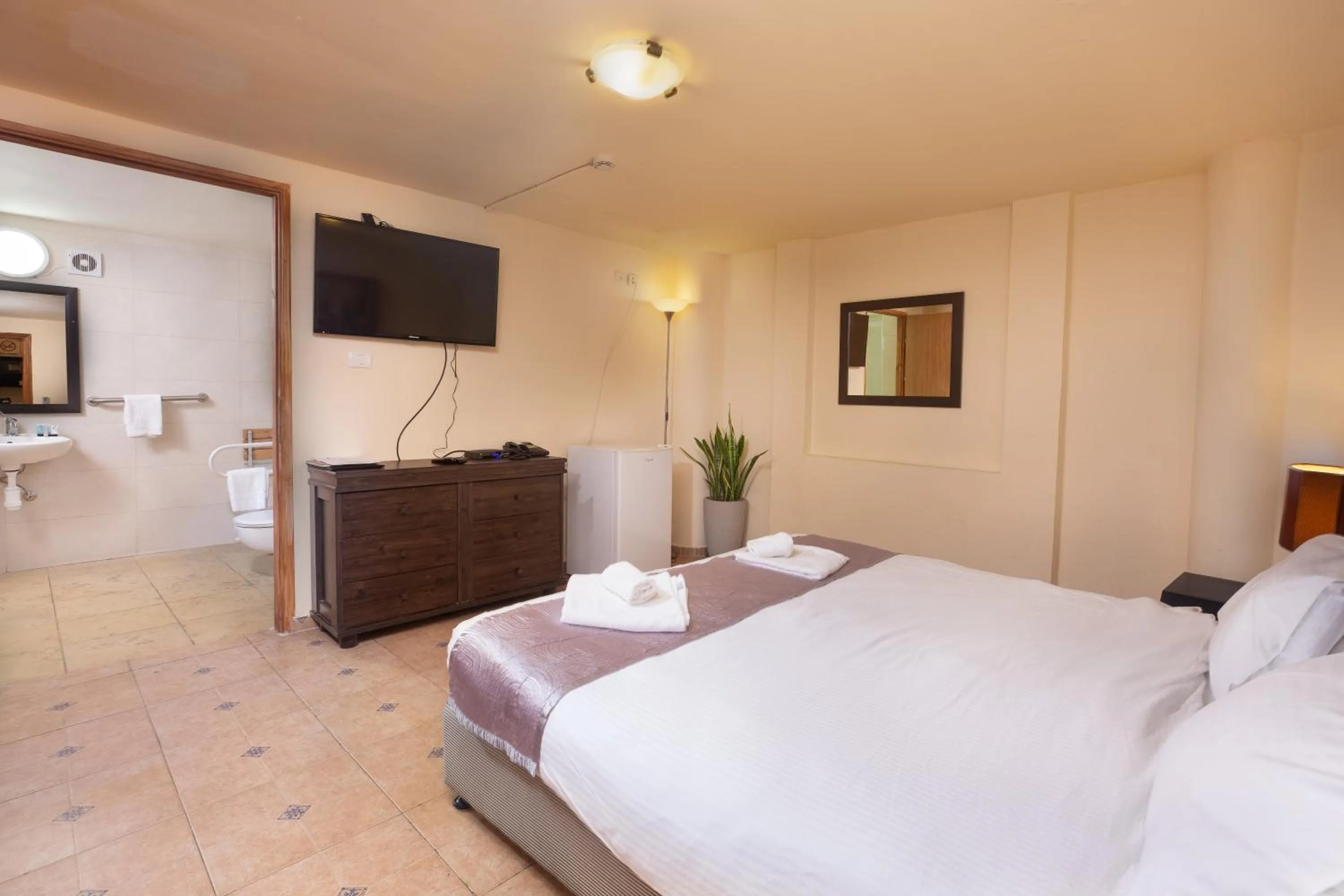 Bed, TV/Entertainment Center in The Colony Hotel