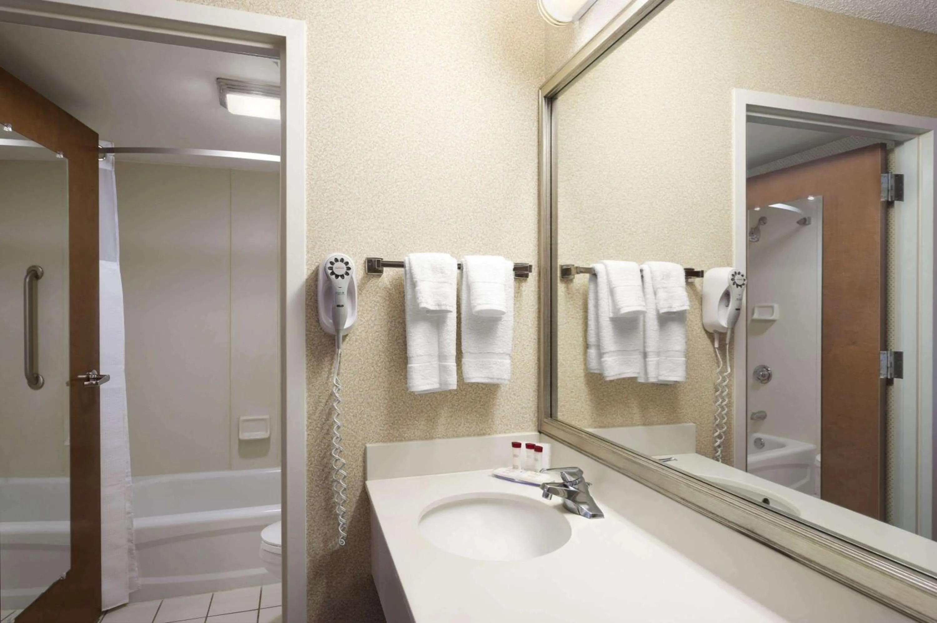 Bathroom in Ramada by Wyndham Suites Orlando Airport- Free Airport Shuttle
