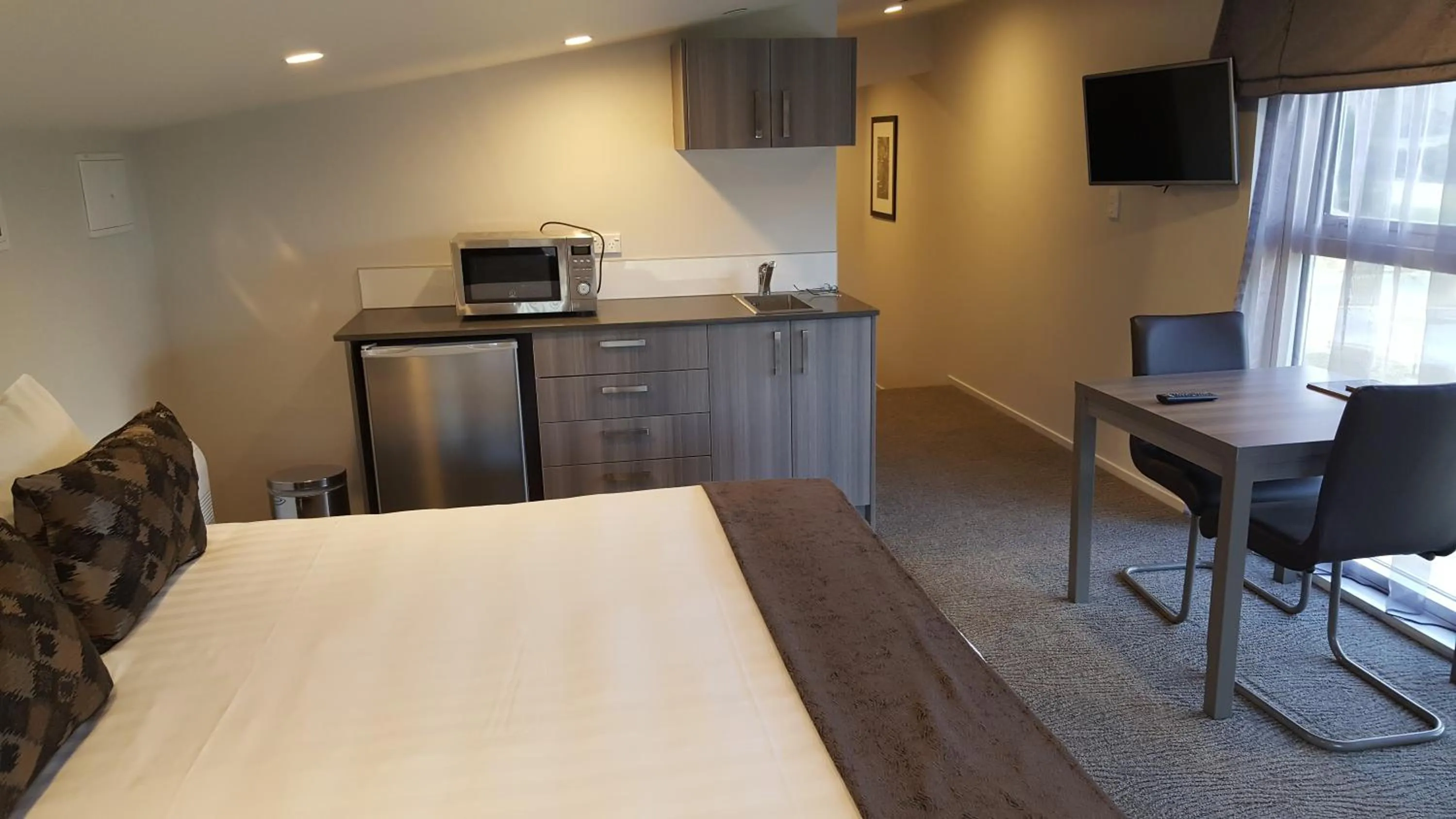 Kitchen or kitchenette, Bed in Ramada Suites by Wyndham Queenstown Remarkables Park