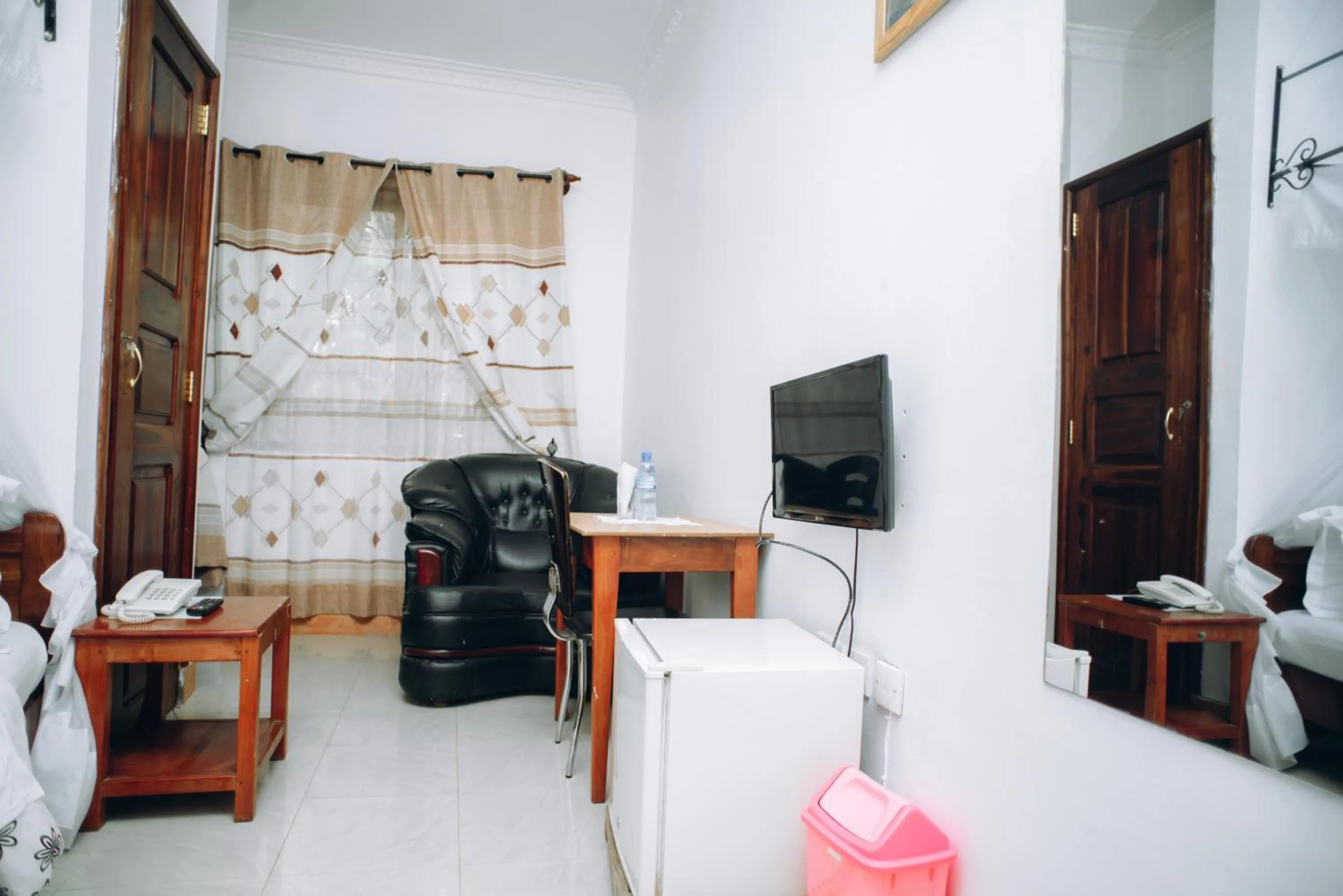 Communal lounge/ TV room, Bed in Arusha Giraffe Lodge