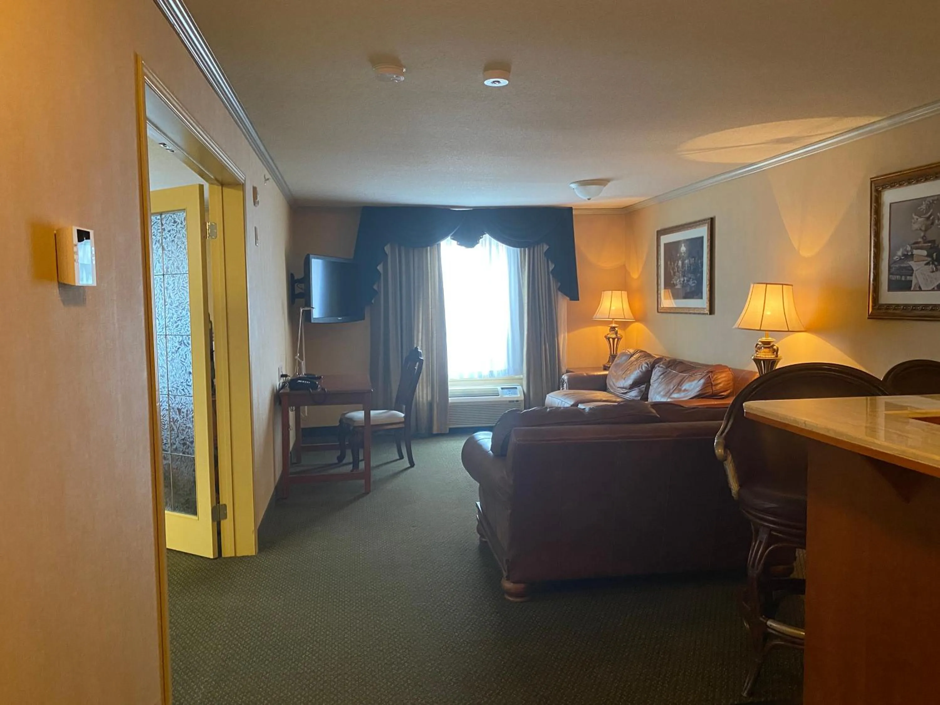 Living room, Bed in Merit Hotel & Suites