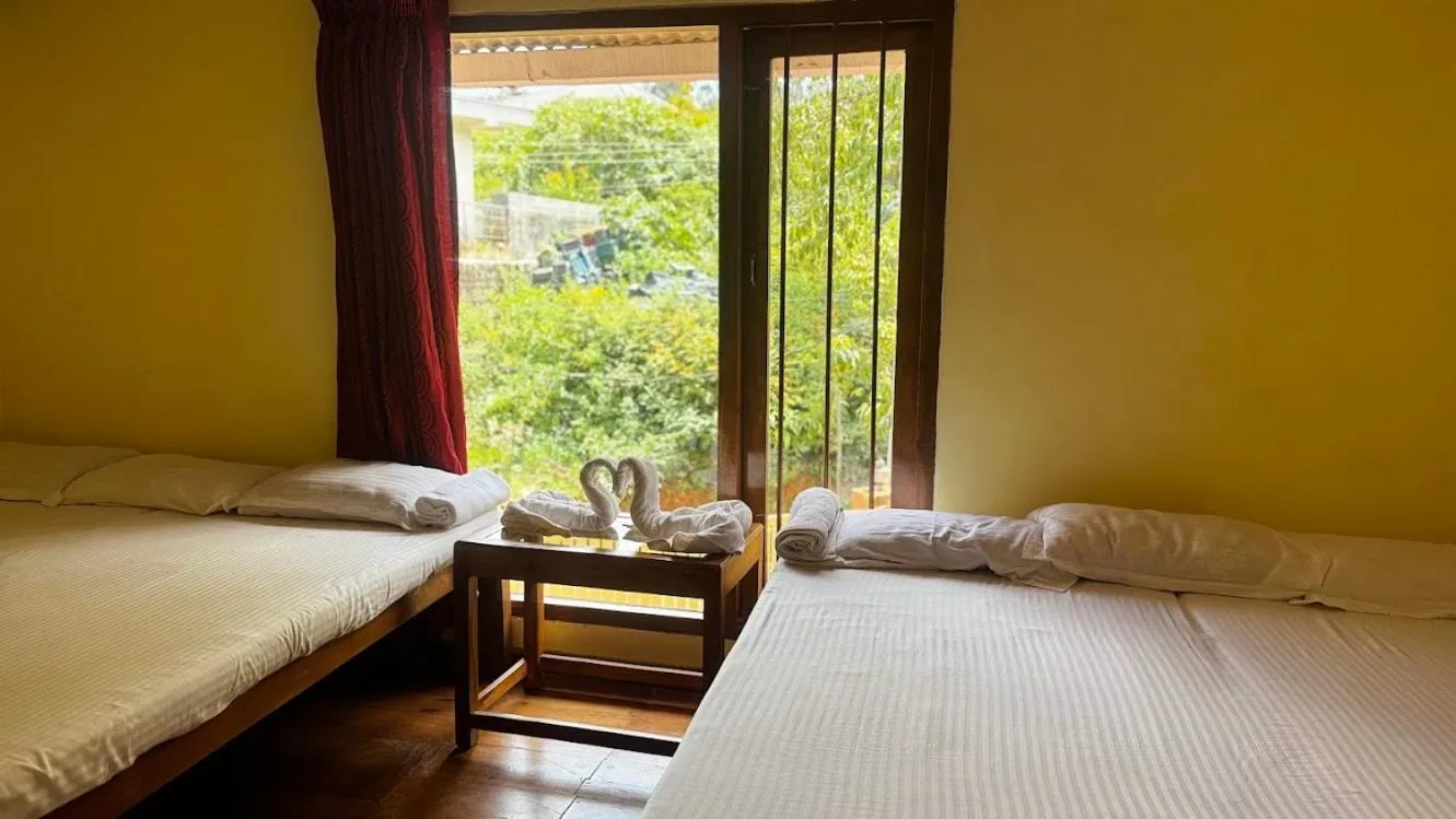 Bed in Satya Anand Cottage Pure Veg and Non Alcoholic Hotel