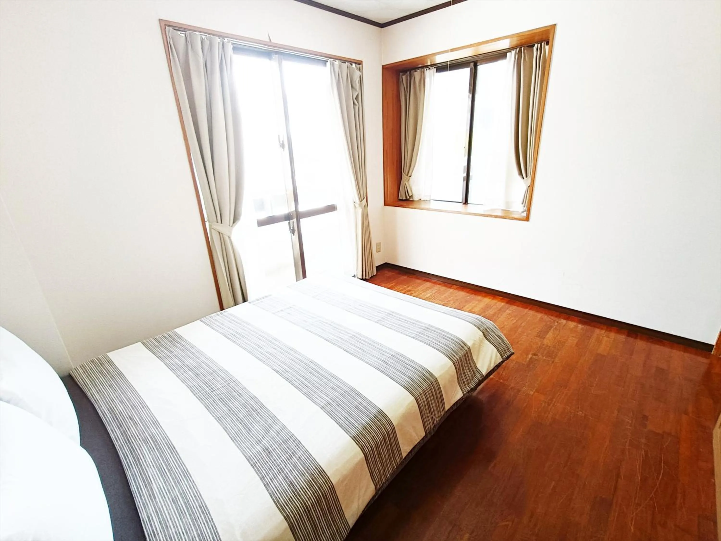 Bed in Kariyushi Condominium Resort Sea Side House