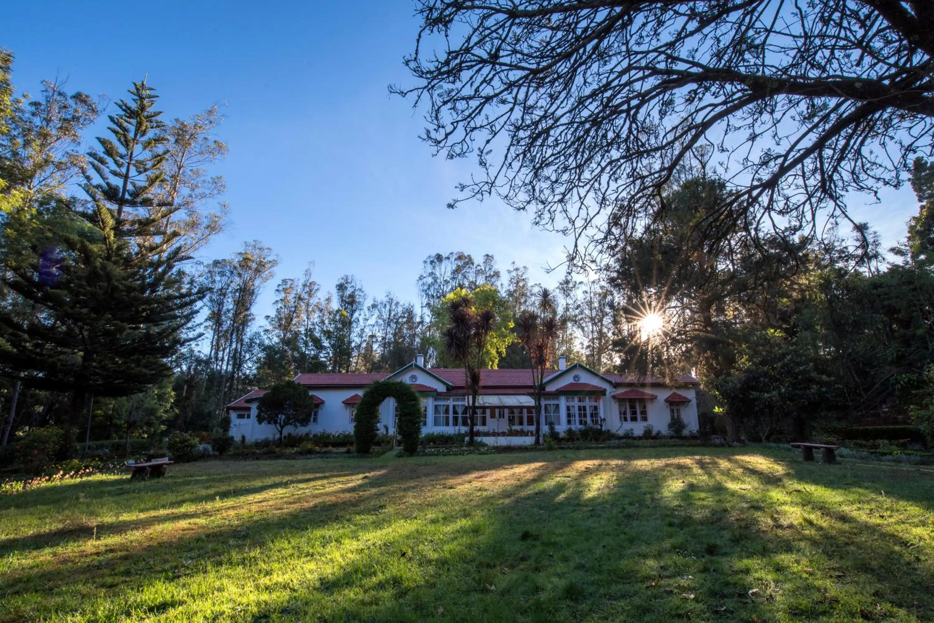 Property building in SaffronStays Milton Abbott Estate - 2BR colonial-era bungalow with garden, golf course views & bonfire nights near Ooty Golf Club