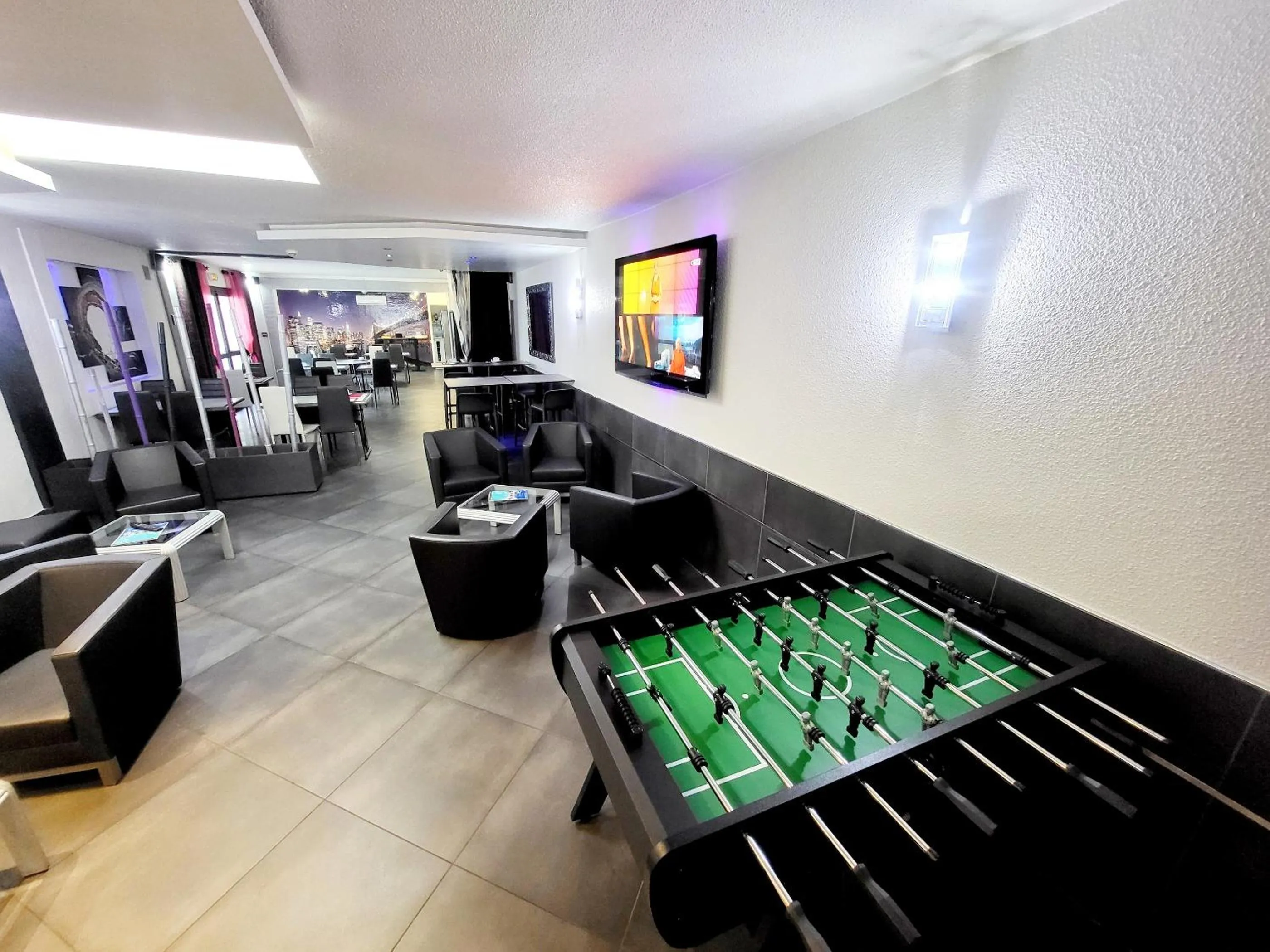 Communal lounge/ TV room in Citotel Hôtel Le Capricorne