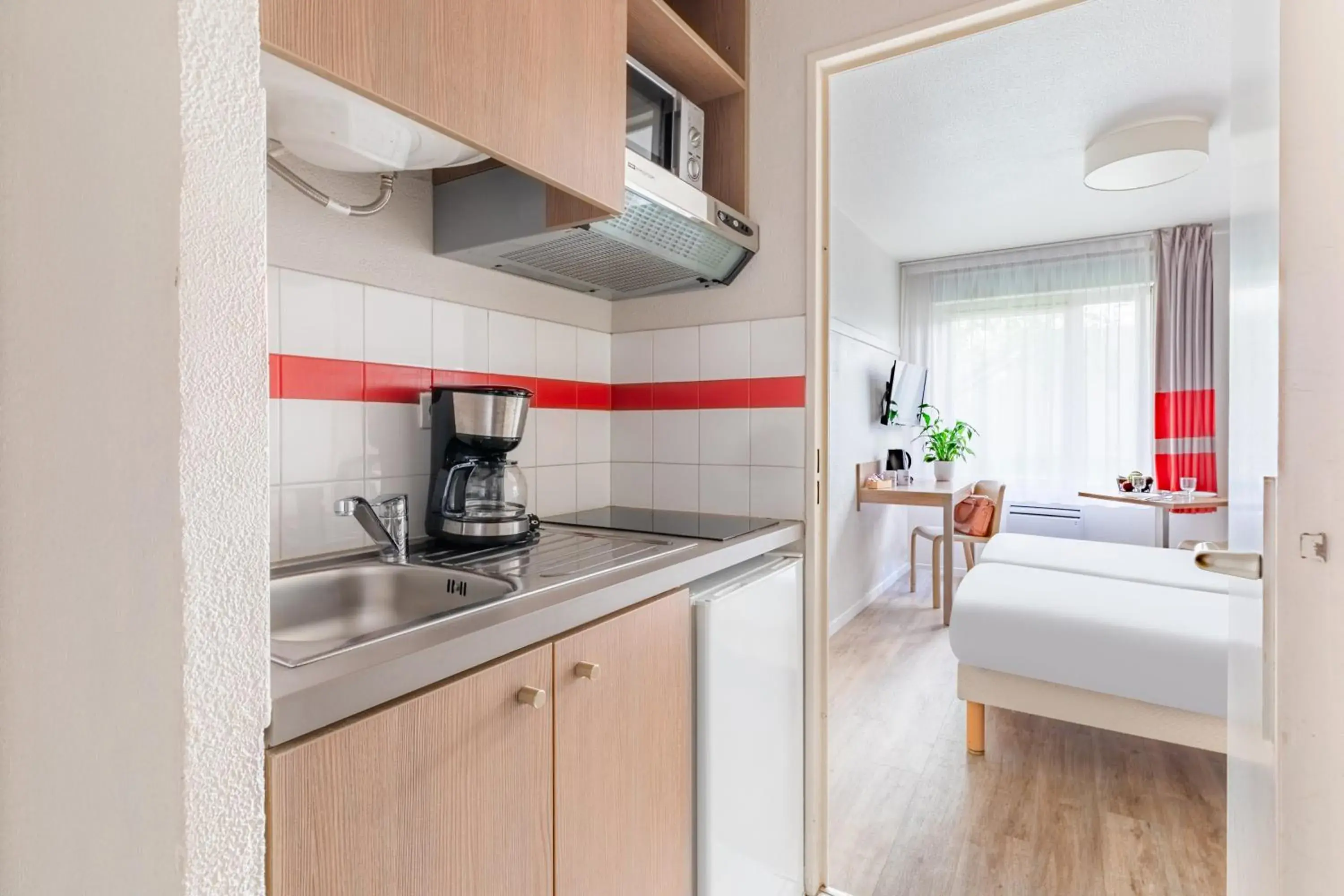 Kitchen or kitchenette, Bed in Appart'City Classic Paris La Villette Kitchen or kitchenette, Bed in Appart'City Classic Paris La Villette