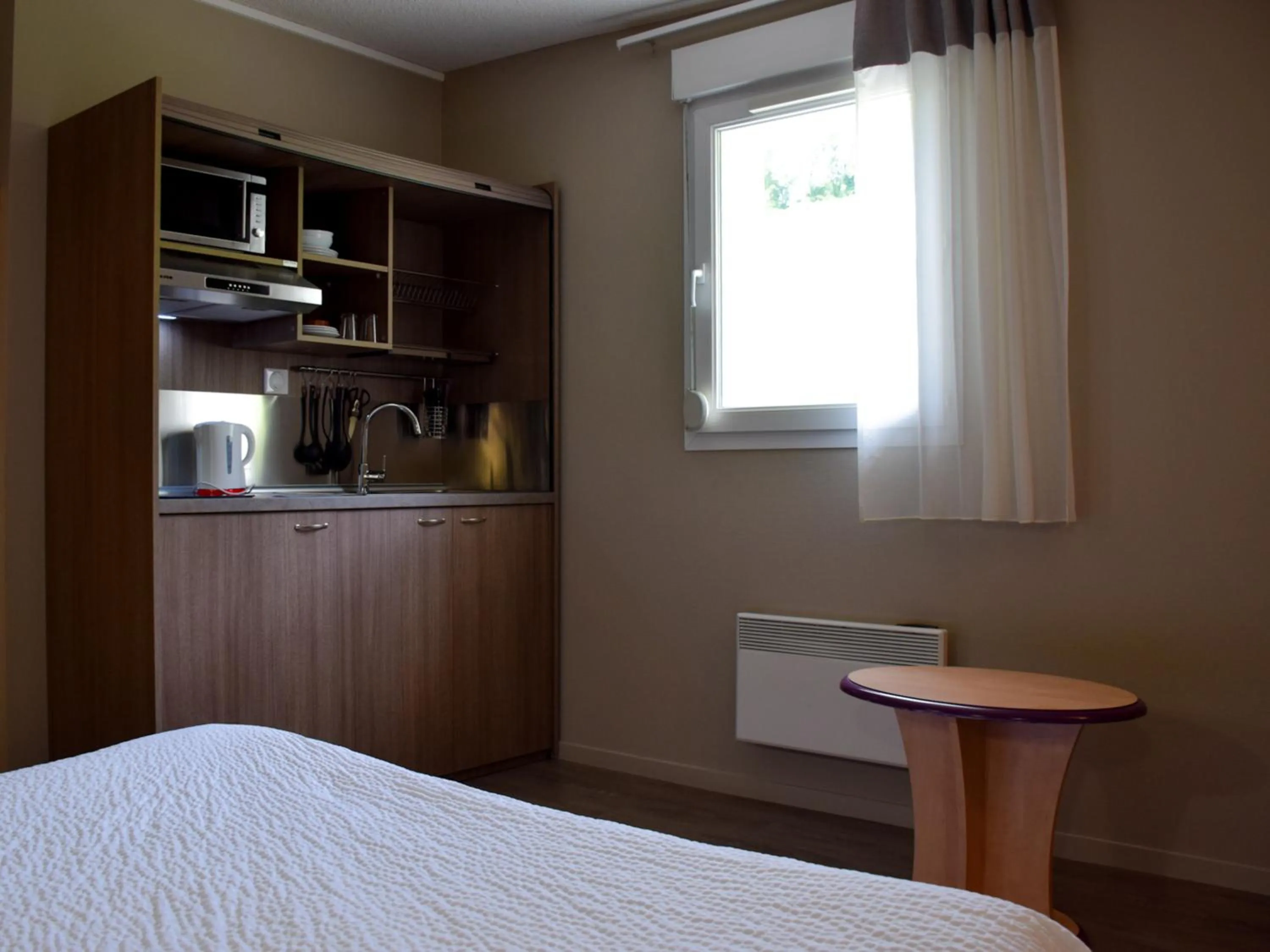 Kitchen or kitchenette, Bed in B&B HOTEL Aurillac Le Lioran