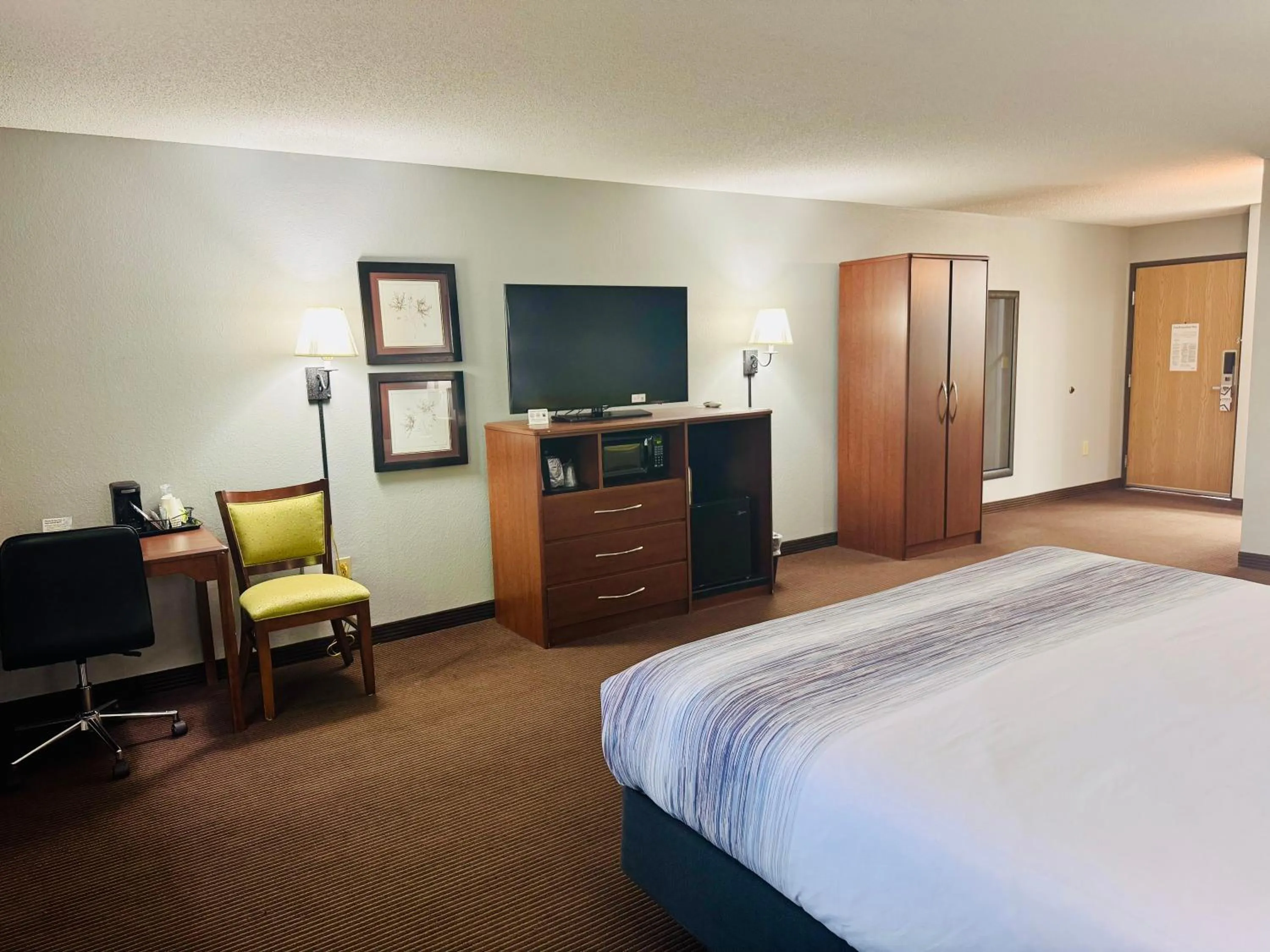 Communal lounge/ TV room, Bed in AmericInn by Wyndham Stillwater