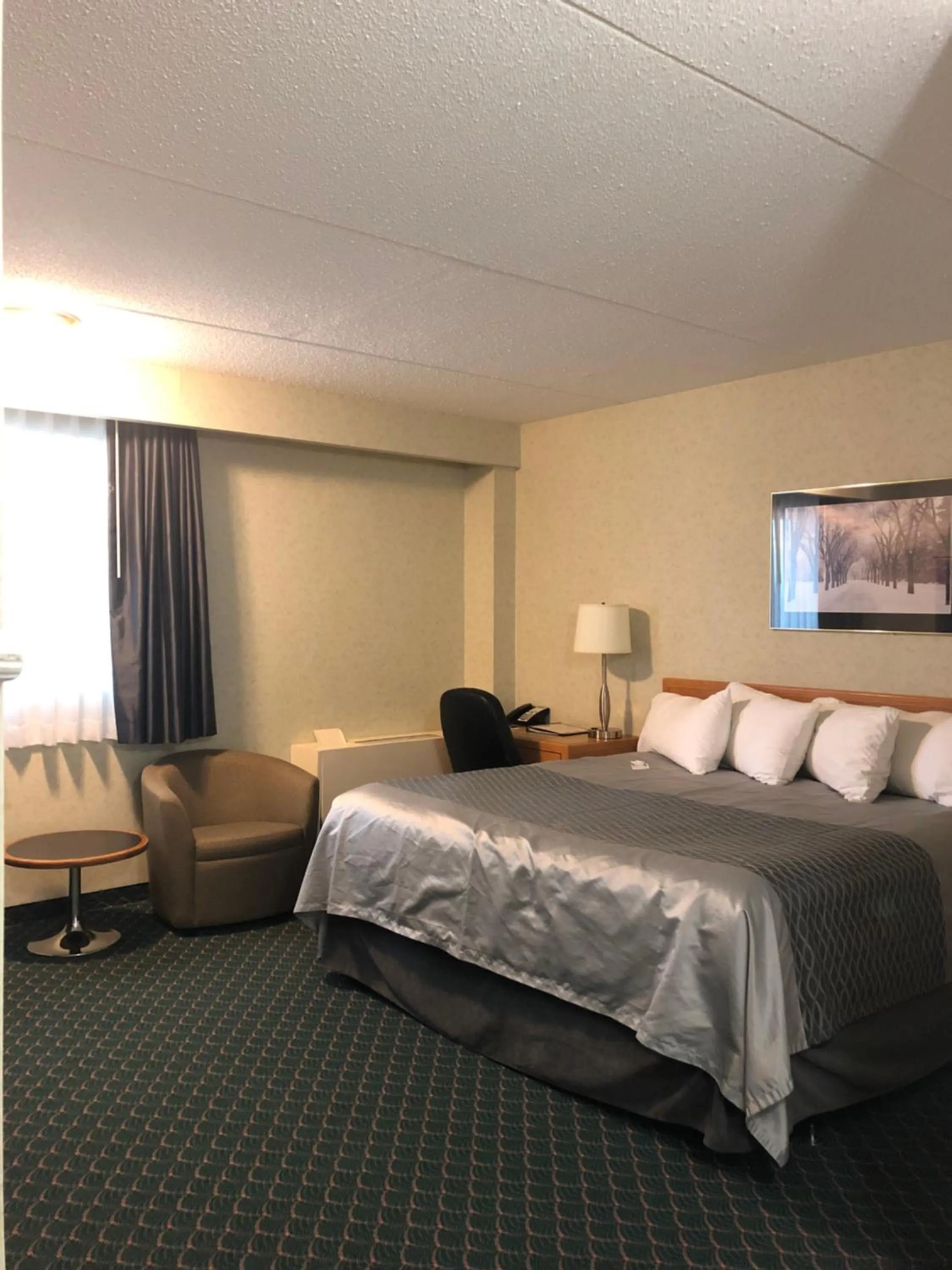 Seating area, Bed in Travelodge by Wyndham Winnipeg East