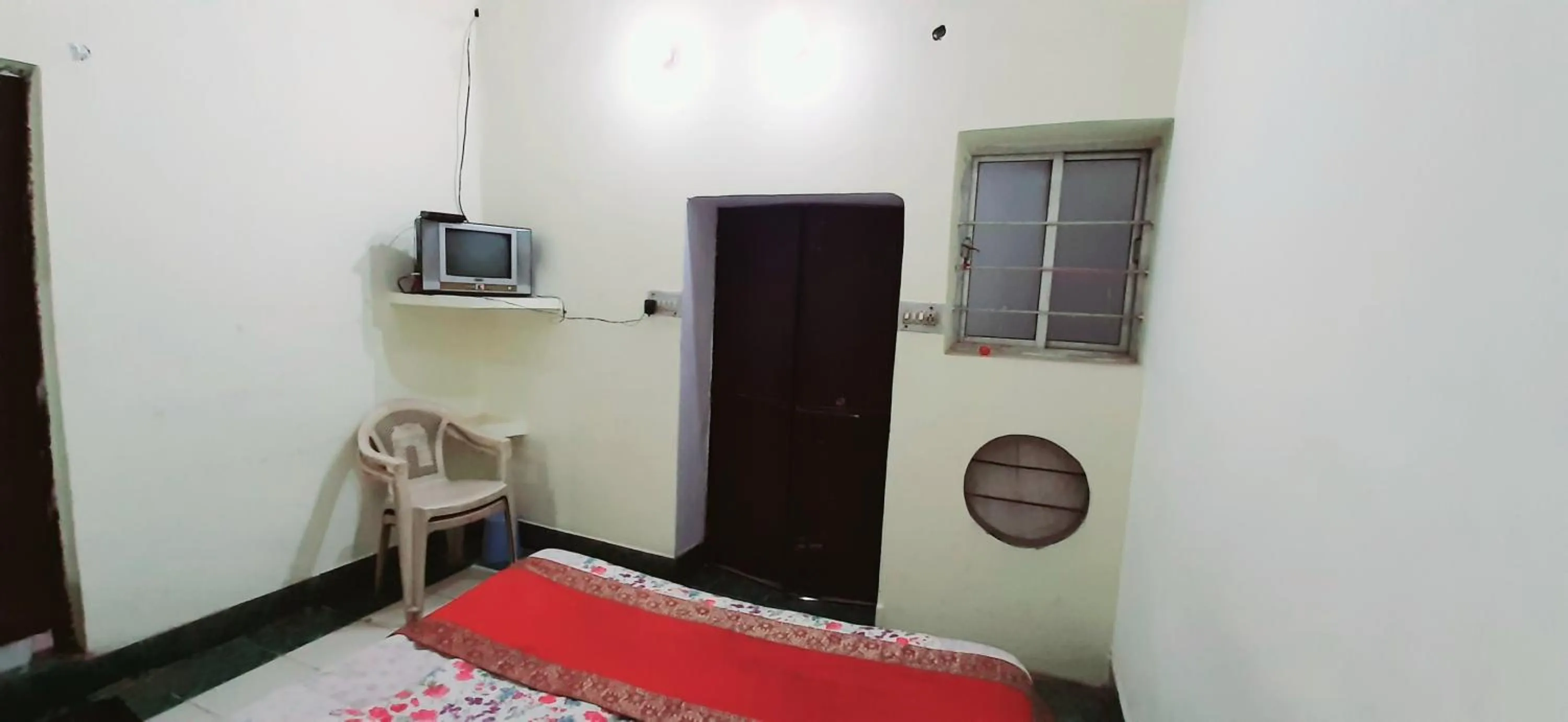 Communal lounge/ TV room, Bed in Luxmi Hotel