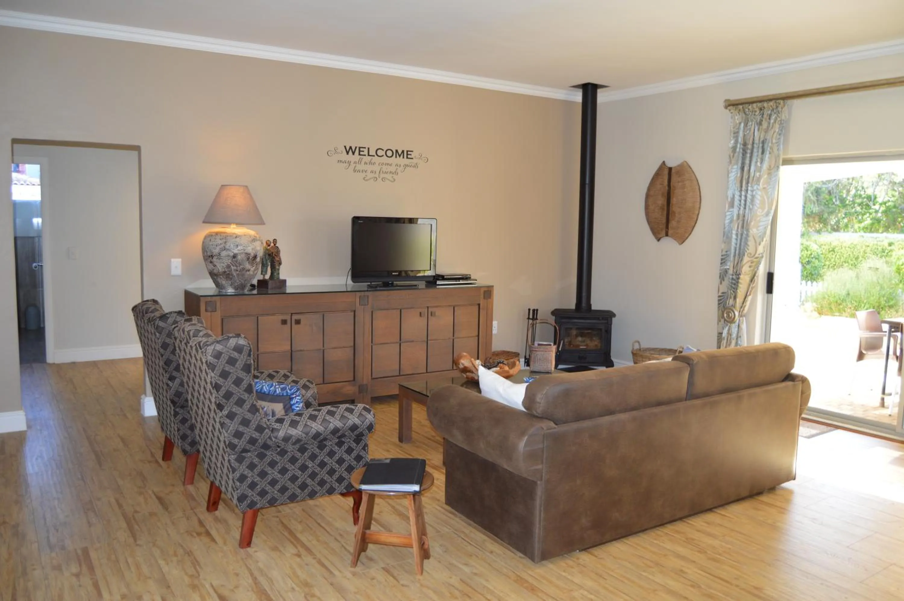 Communal lounge/ TV room in African Palm Cottage and Guesthouse