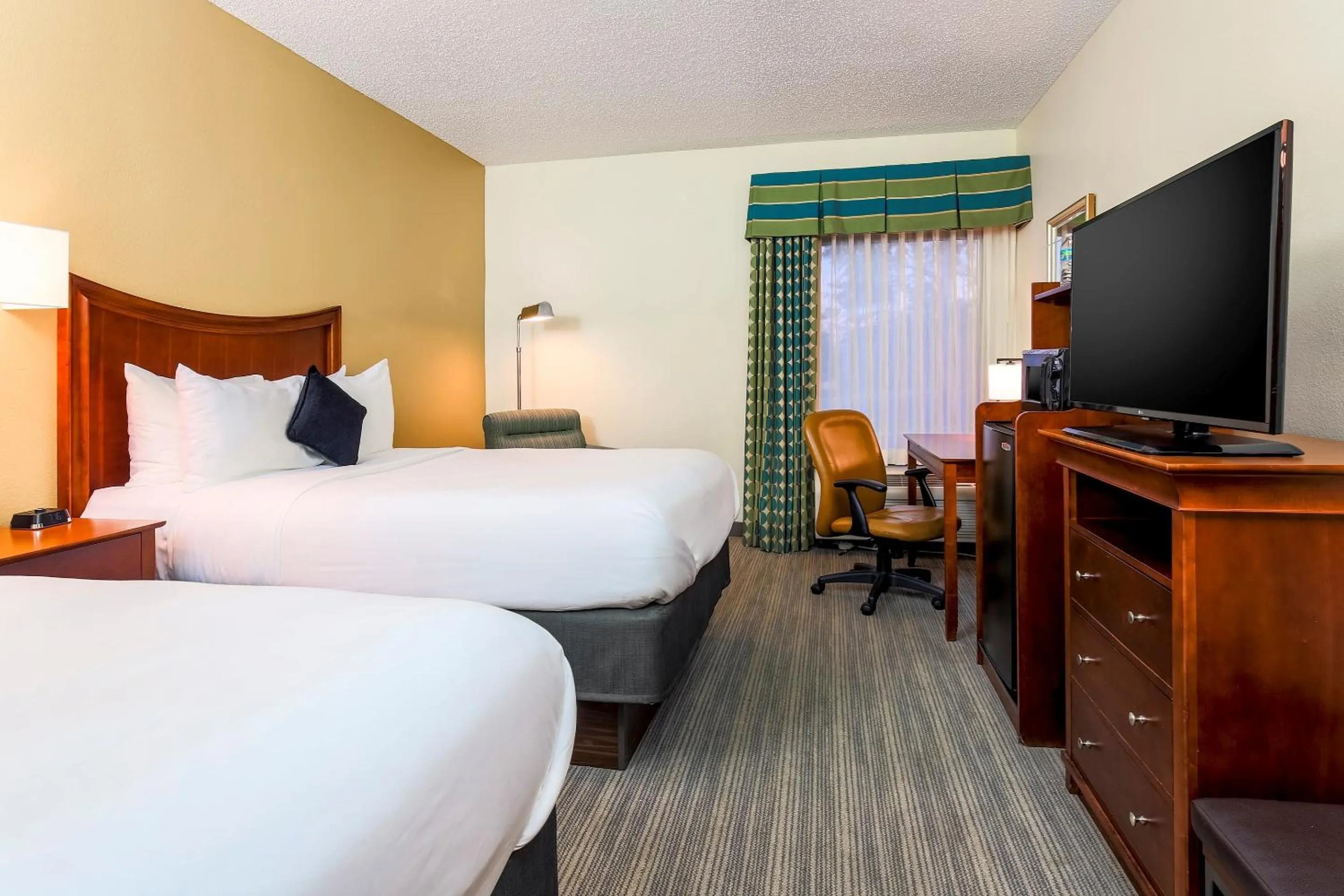 Bed, TV/Entertainment Center in Red Lion Inn & Suites Hattiesburg
