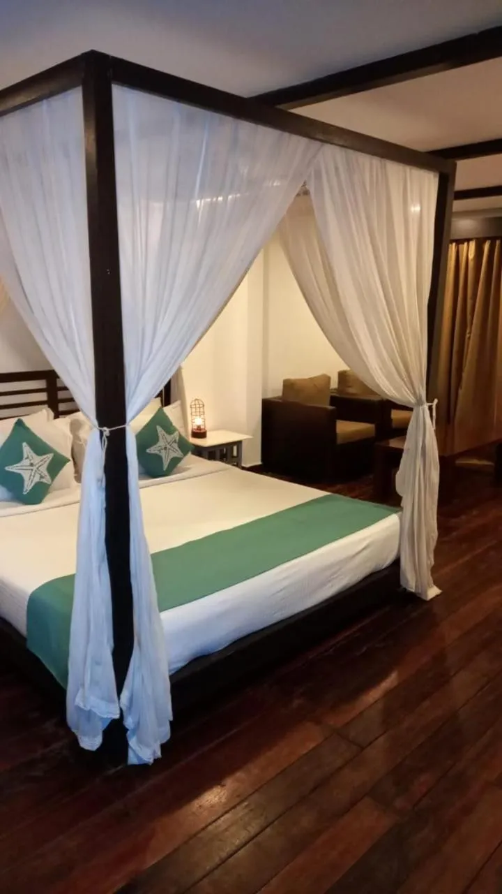 Seating area, Bed in SinQ Beach Morjim