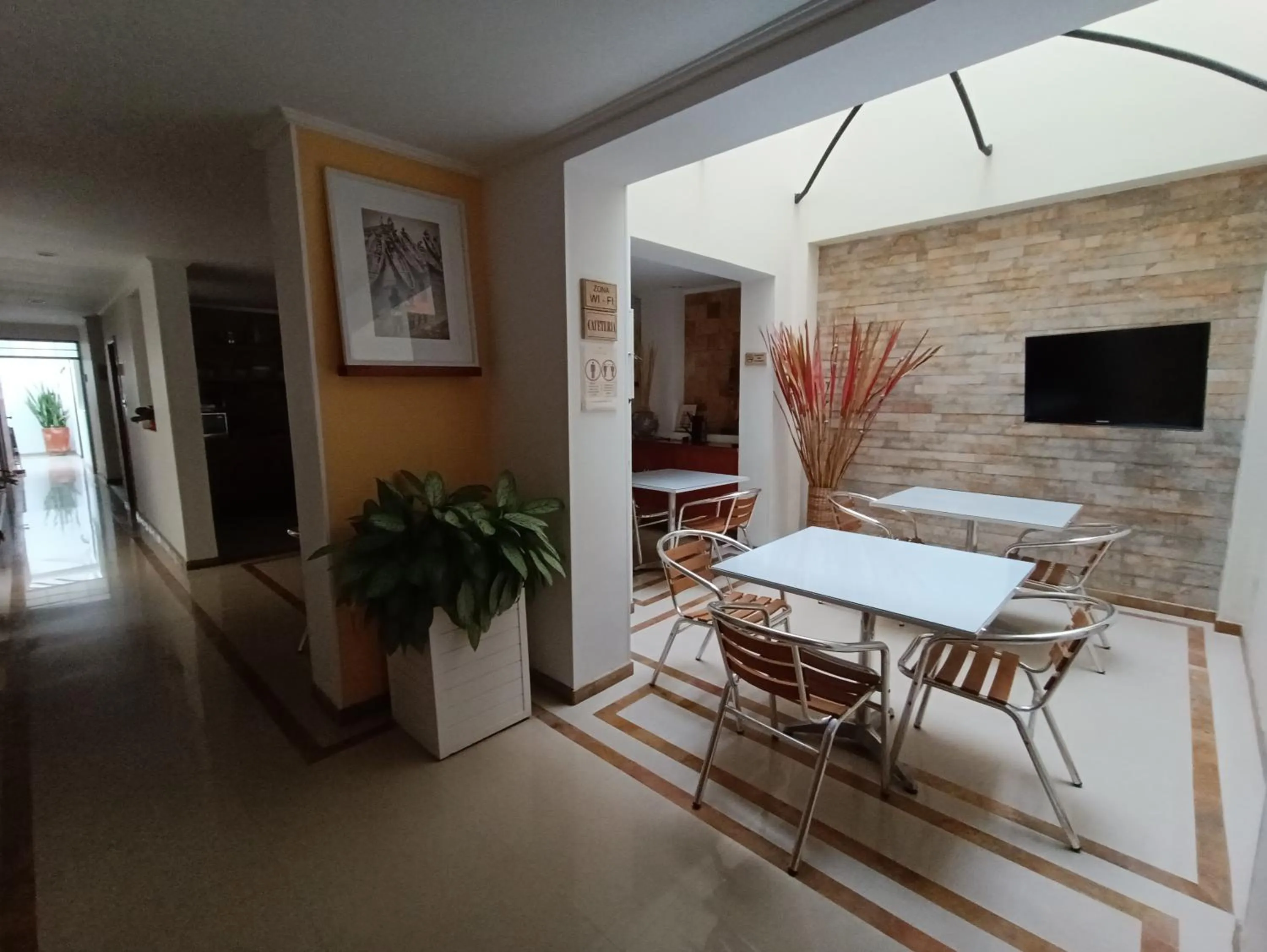 Communal lounge/ TV room in Hotel Boutique Confort Suites