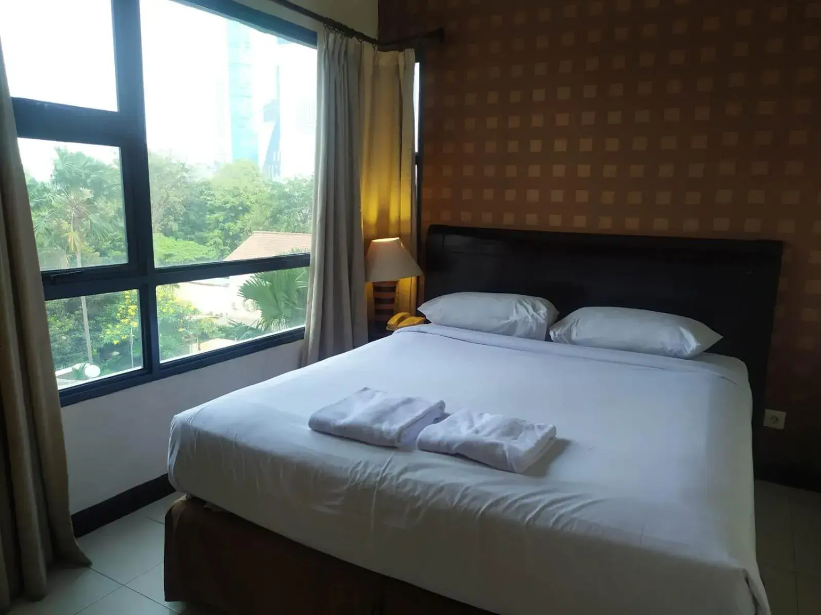 Bed in Grand Tropic Suites Hotel